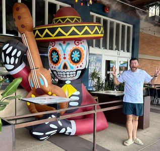 Brandon enjoying life outside of a restaurant with a sugar skull inflatable!