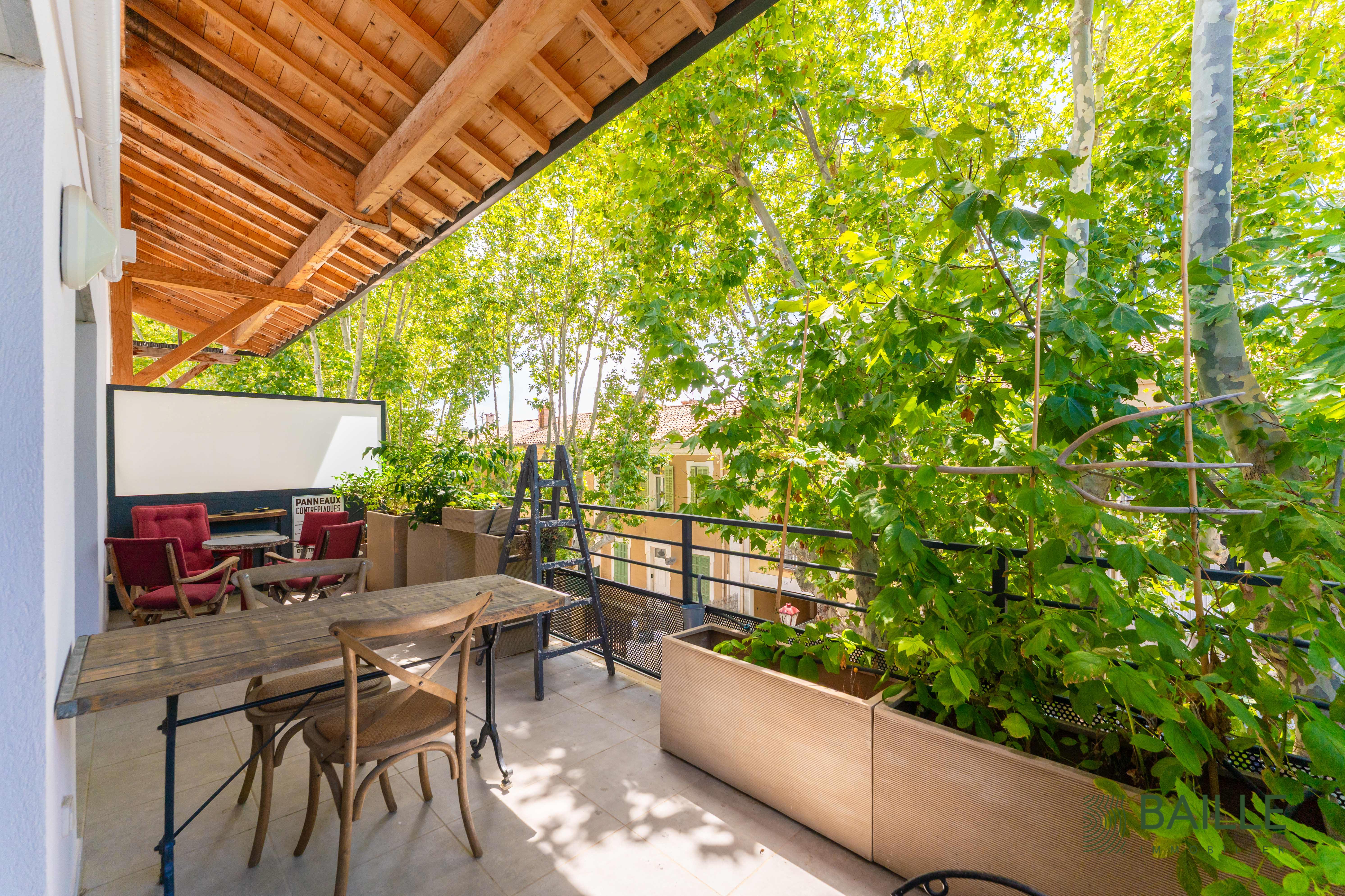 Terrasse accueillant un salon et un espace repas