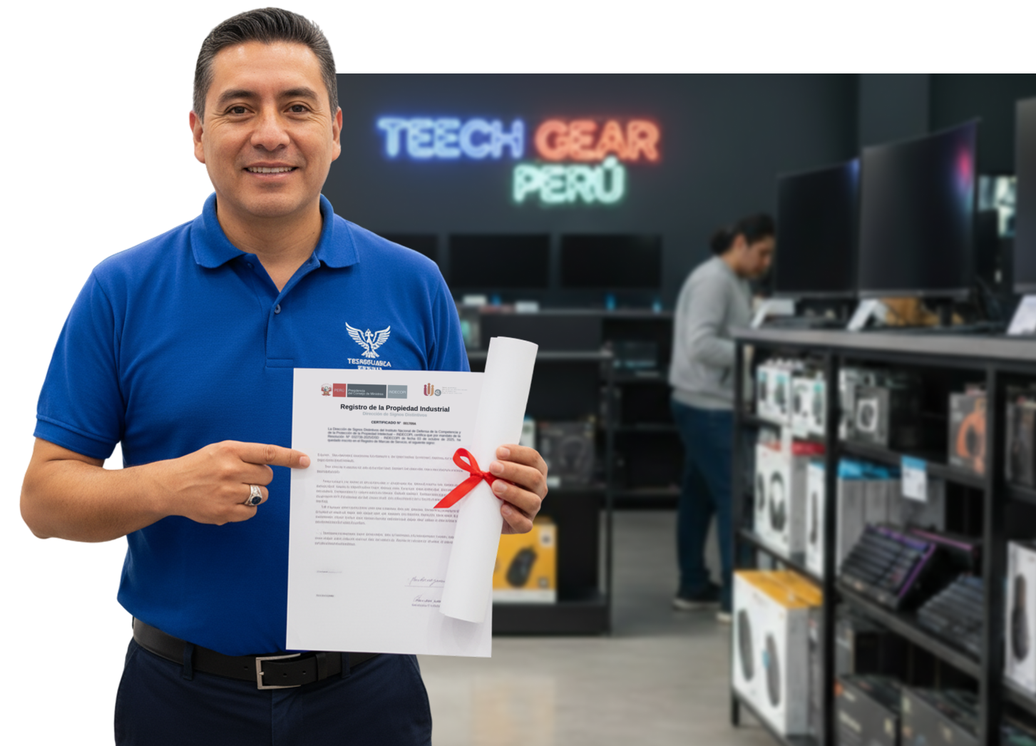 Hombre sonriente con camiseta azul sosteniendo y señalando un certificado de registro de propiedad industrial en una tienda de tecnología.