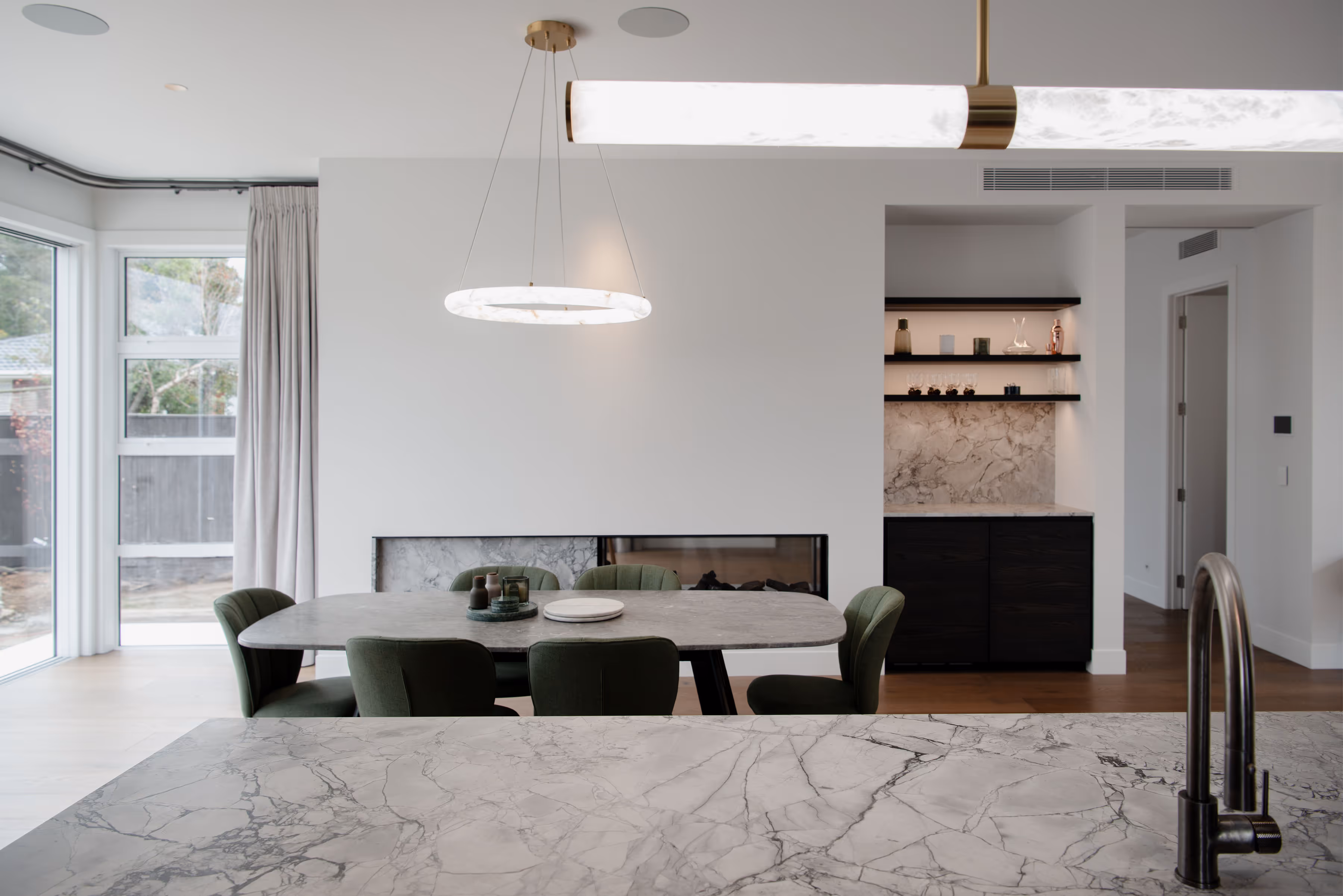 A beautifully renovated character villa featuring a modern extension with large glass doors opening to an inviting outdoor deck and swimming pool. Designed by Hoxha Bailey Architects, this home seamlessly merges classic architectural details with contemporary open-plan living. The outdoor space is complemented by stylish outdoor seating, a glass pool fence, and lush greenery, enhancing indoor-outdoor flow and functionality.