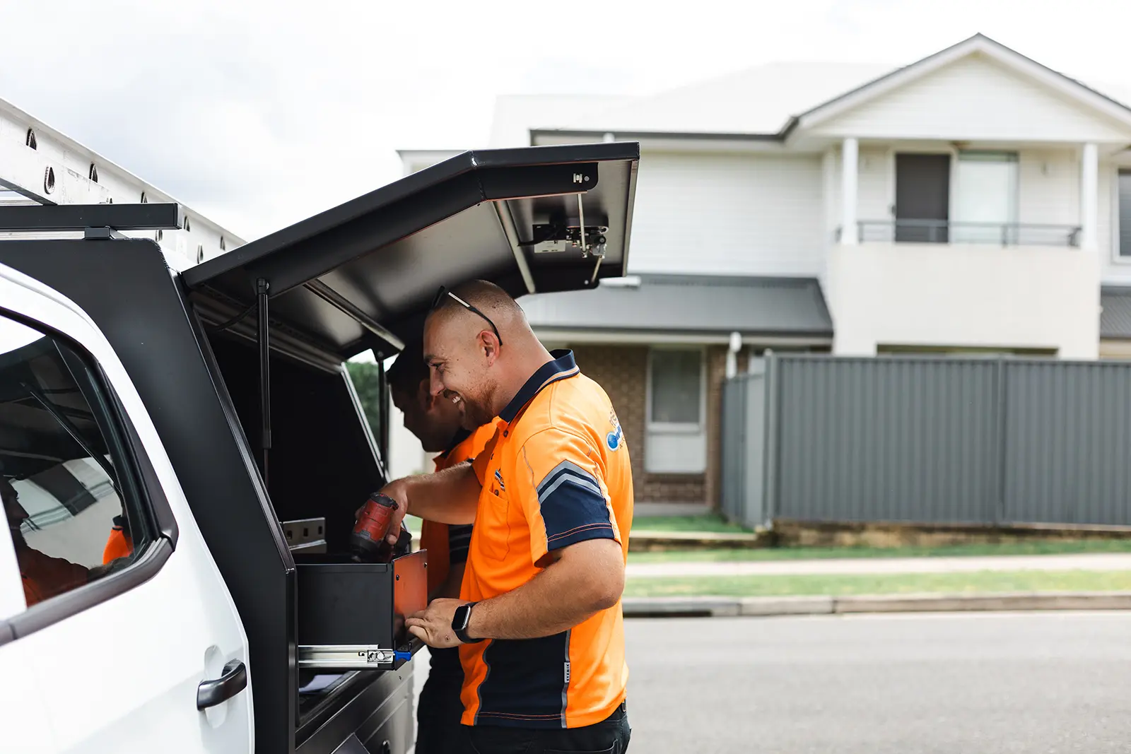 tradesman looking inside a tool box in a car