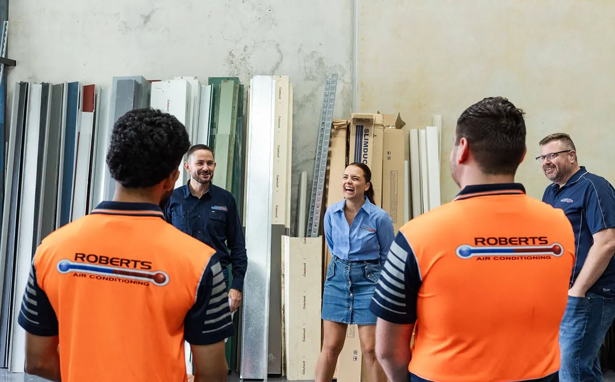 group of people talking and smiling at roberts air conditioning warehouse