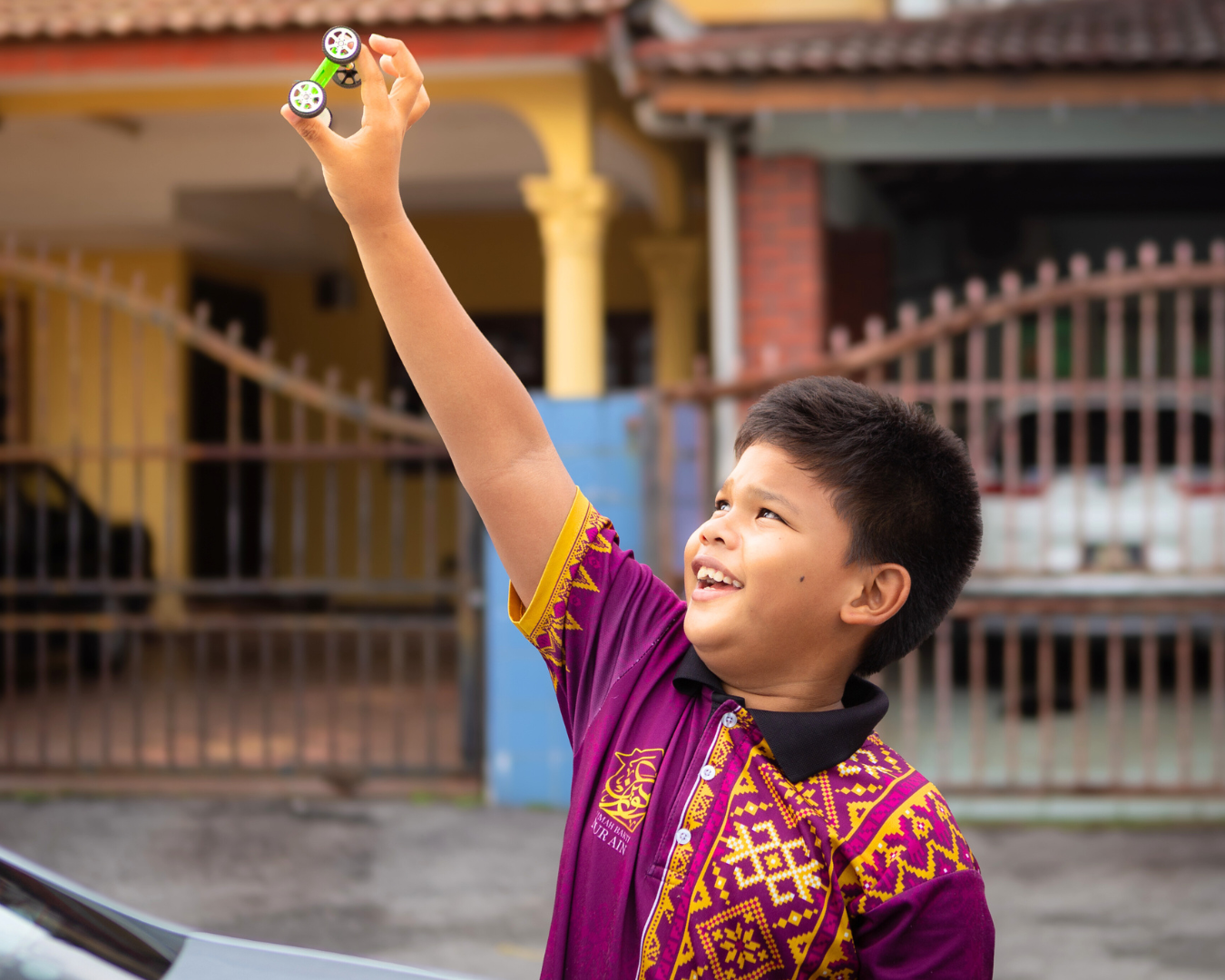 A young boy charging his toy solar-powered car with the sun