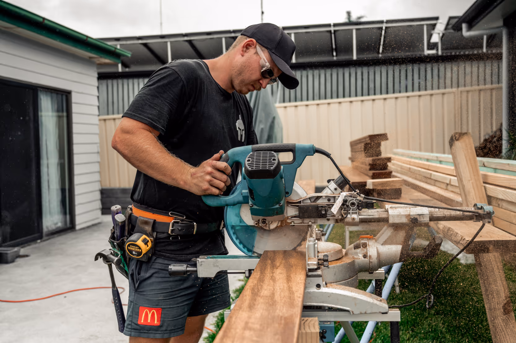 A man using a circular saw on a large plank of wood