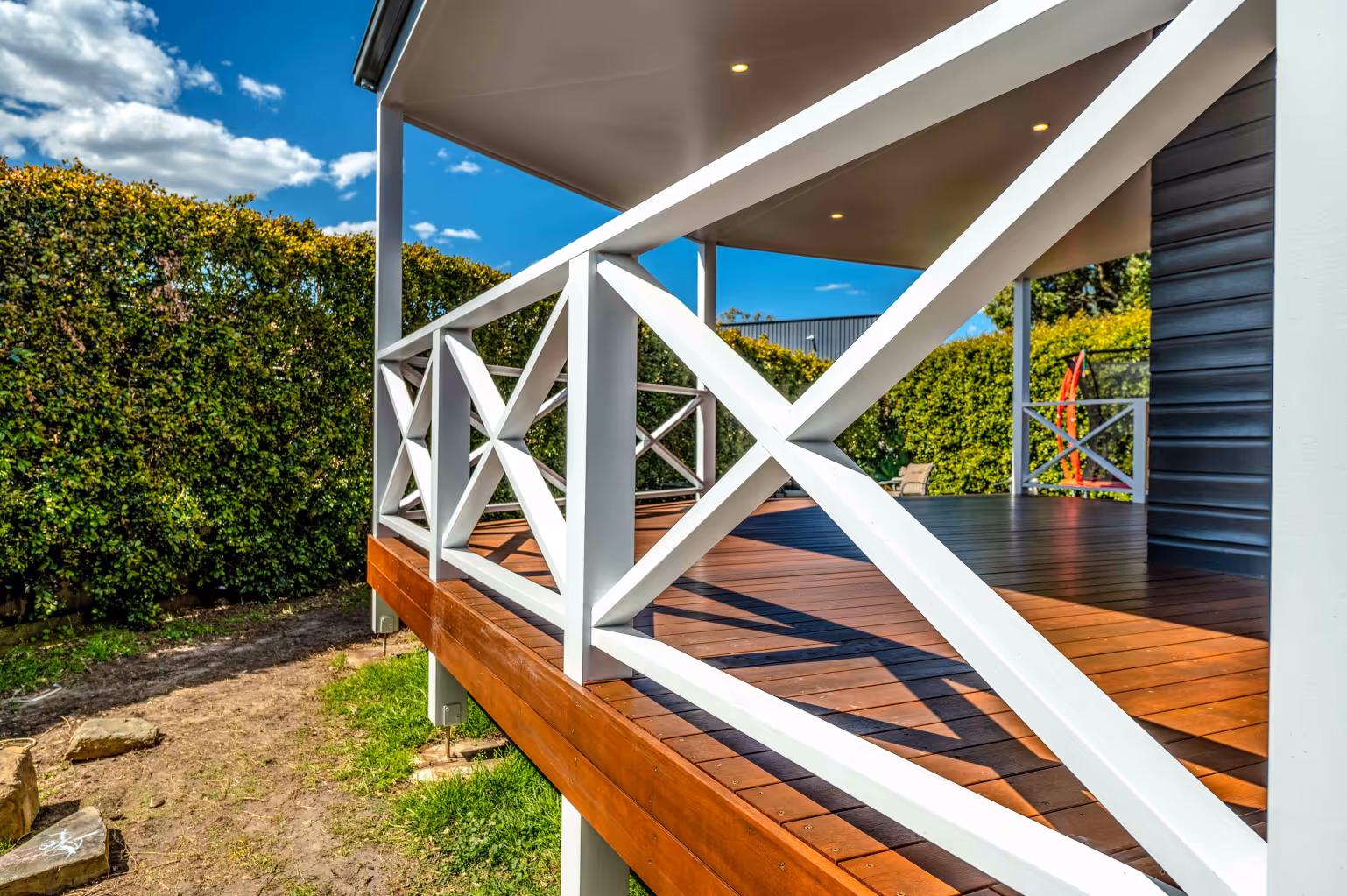 A deck surrounding a blue house