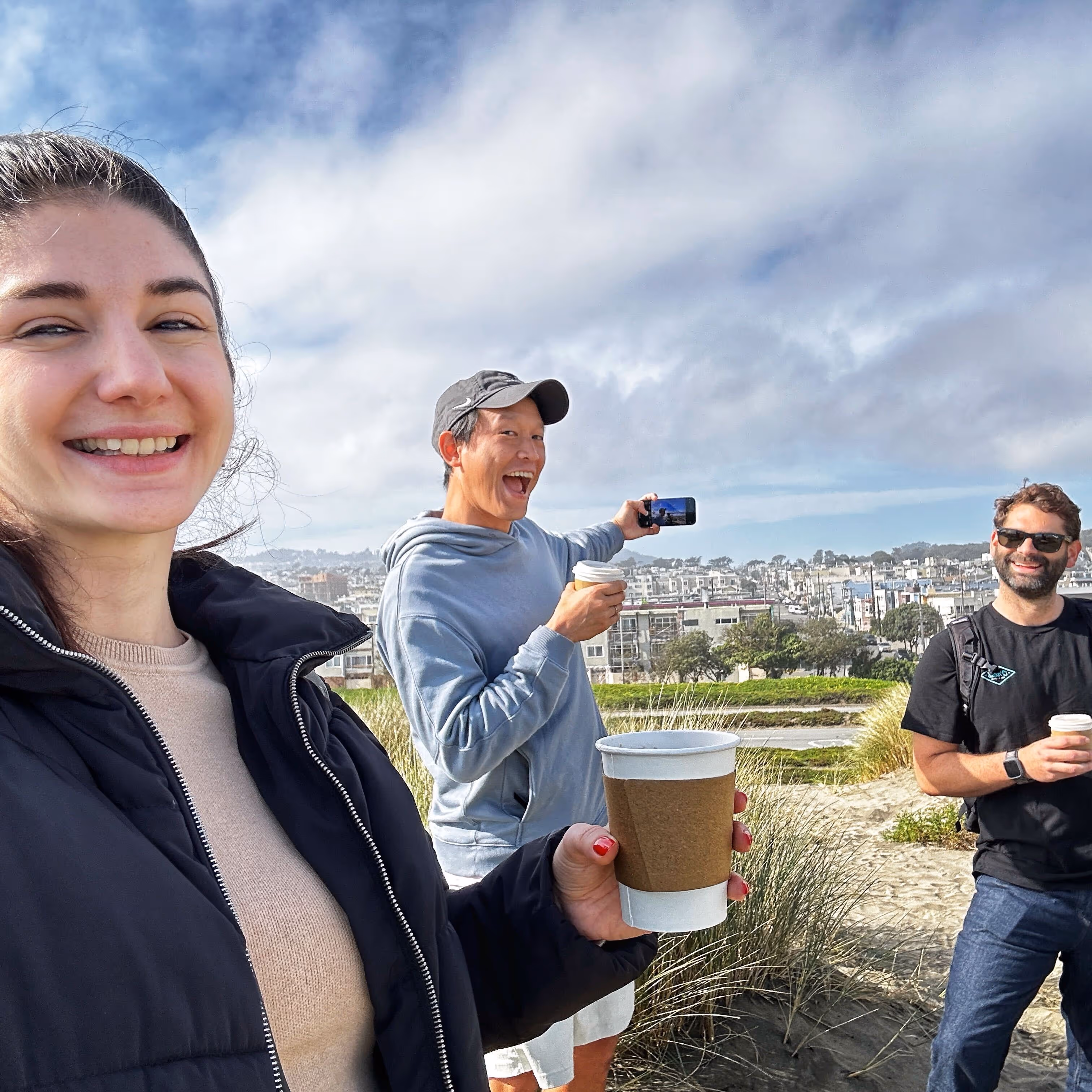 Three Verdigris team members stand outside smiling during a hike in the San Francisco Bay Area