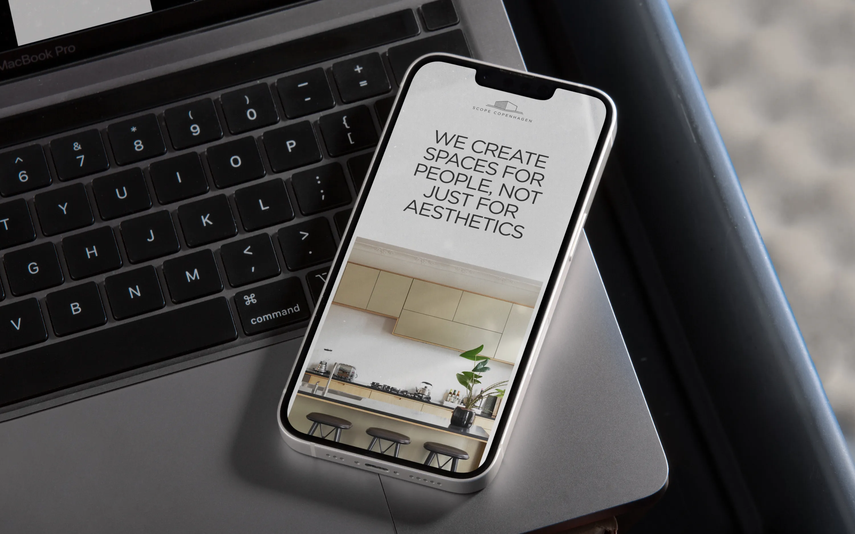 Smartphone on laptop showing a quote about creating spaces for people with a kitchen background.