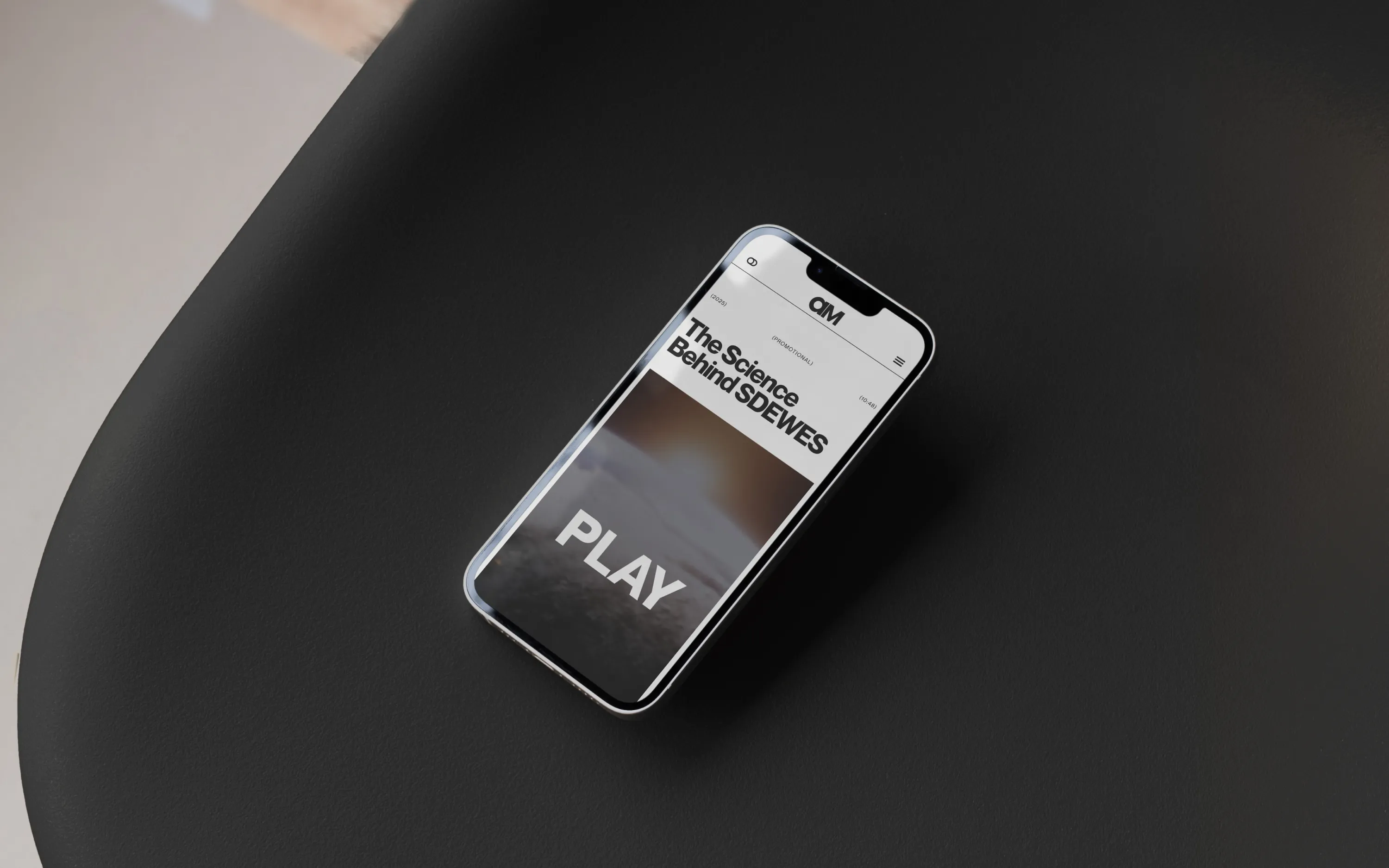 Smartphone on black surface showing a video titled 'The Science Behind SDEWES' with a play button.