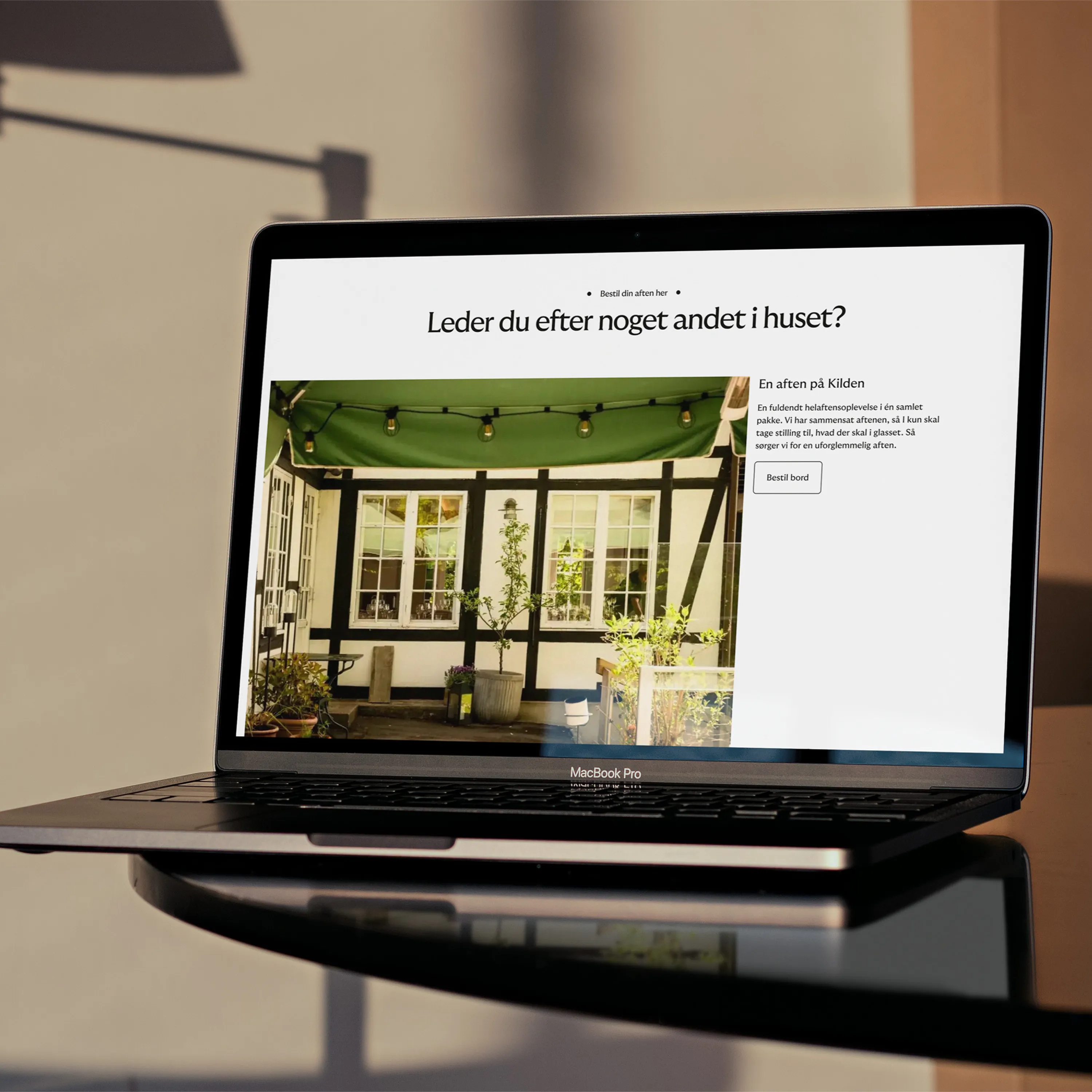 MacBook Pro showing a webpage with outdoor patio and Danish text about booking a table.