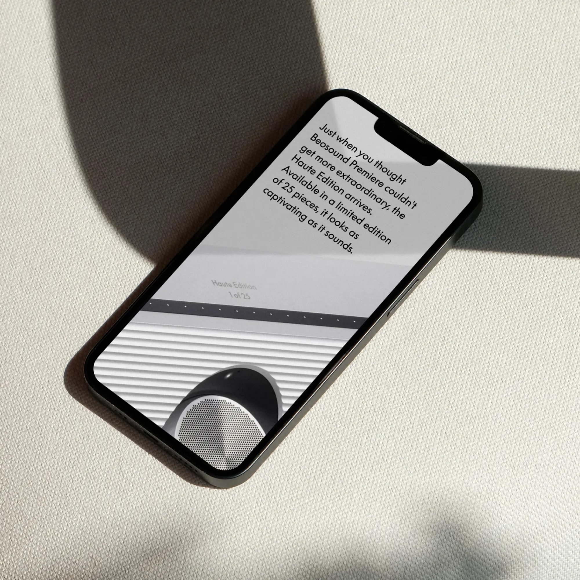 Smartphone on white fabric displaying text about Beosound Premiere Haute Edition limited to 25 pieces.