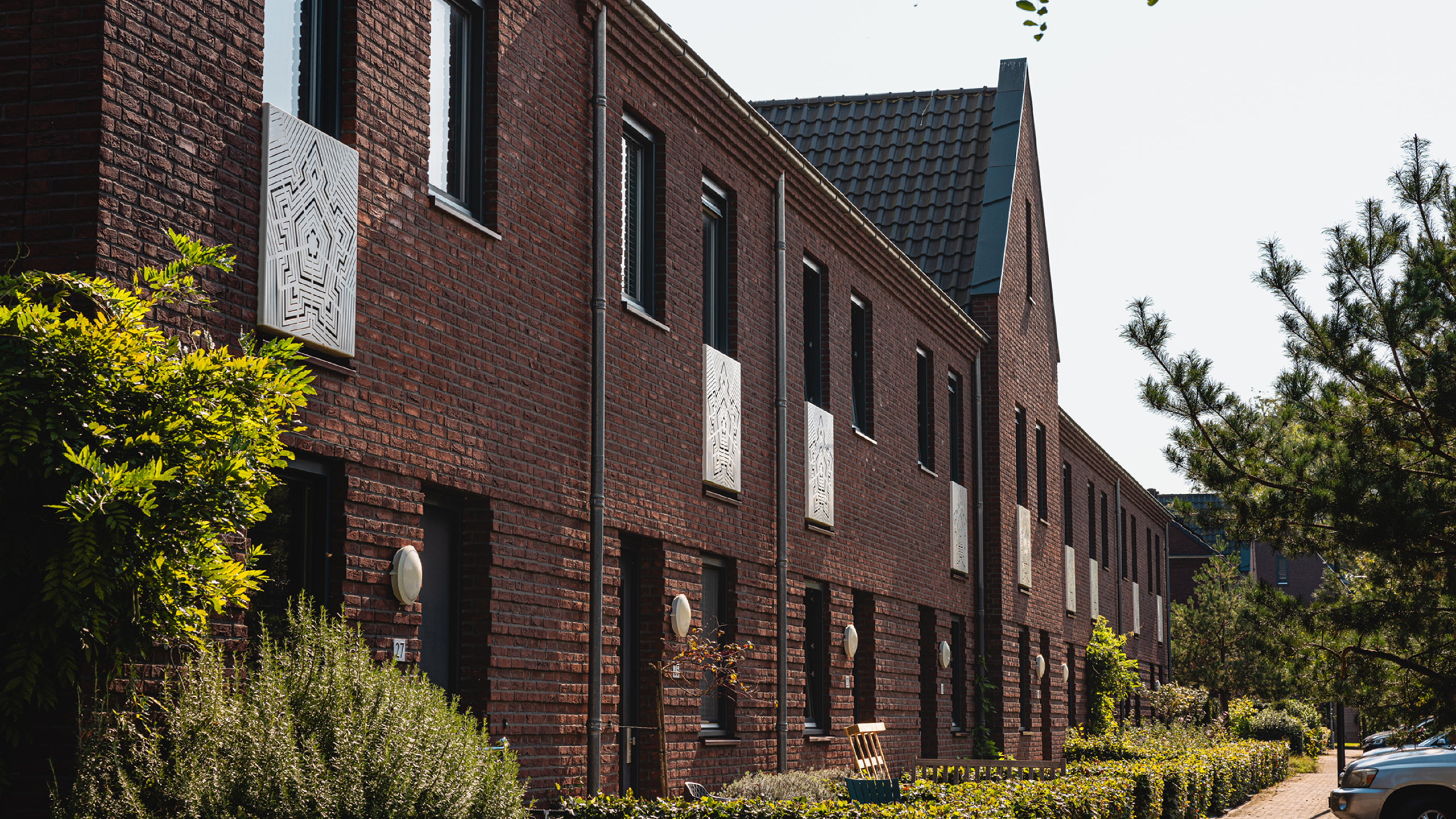 Ontwerpvisualisatie van karaktervolle woningen in Vught met rode baksteen en steile kappen.