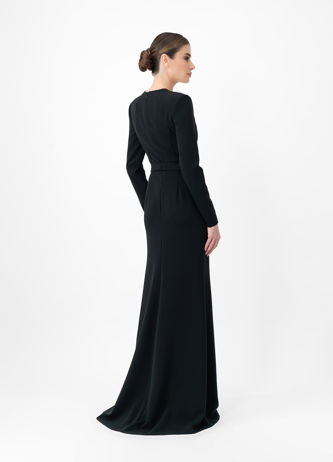 Black dress MA2025P20022 BL- Long sleeve maxi dress with decorative belt, embellished with stone roses. Zipper in the center of the back.