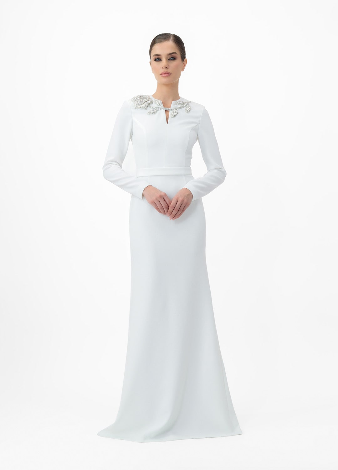 White dress MA2025P20022 W- Long sleeve maxi dress with decorative belt, embellished with stone roses. Zipper in the center of the back.