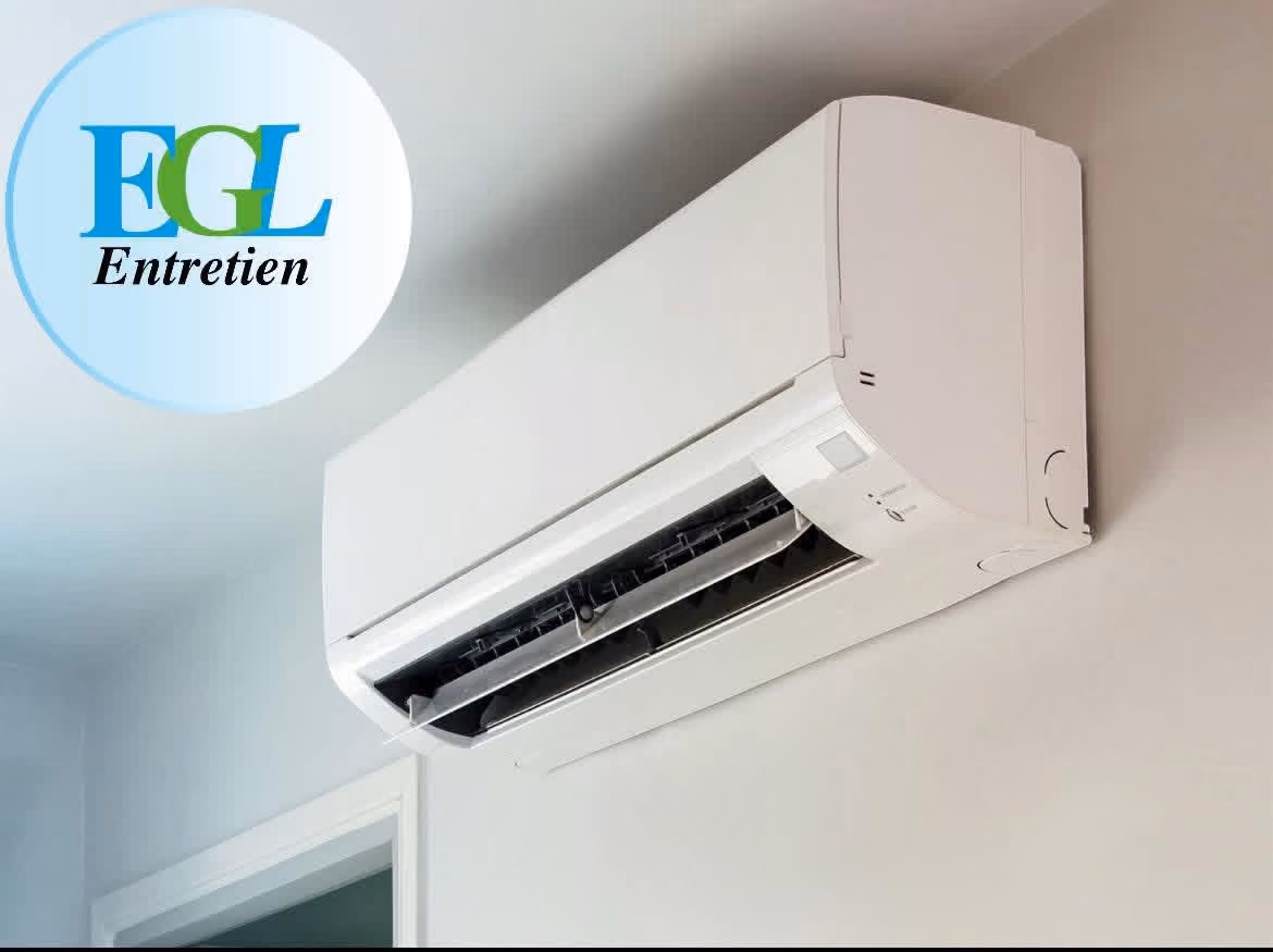 Une thermopompe murale blanche installé au-dessus d’une porte à l’intérieur d’une pièce.