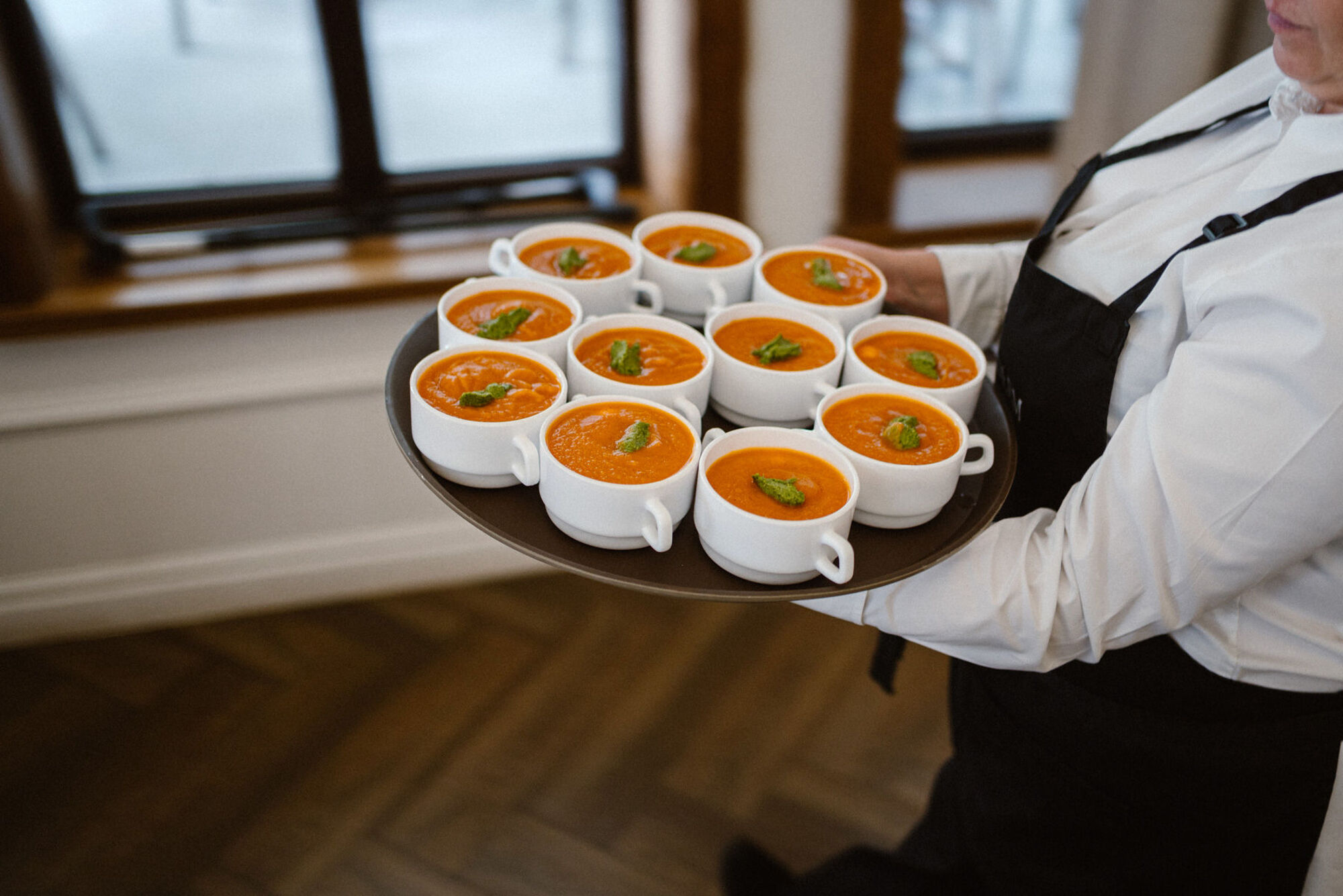 Kelnerka niesie na tacy miski z zupą