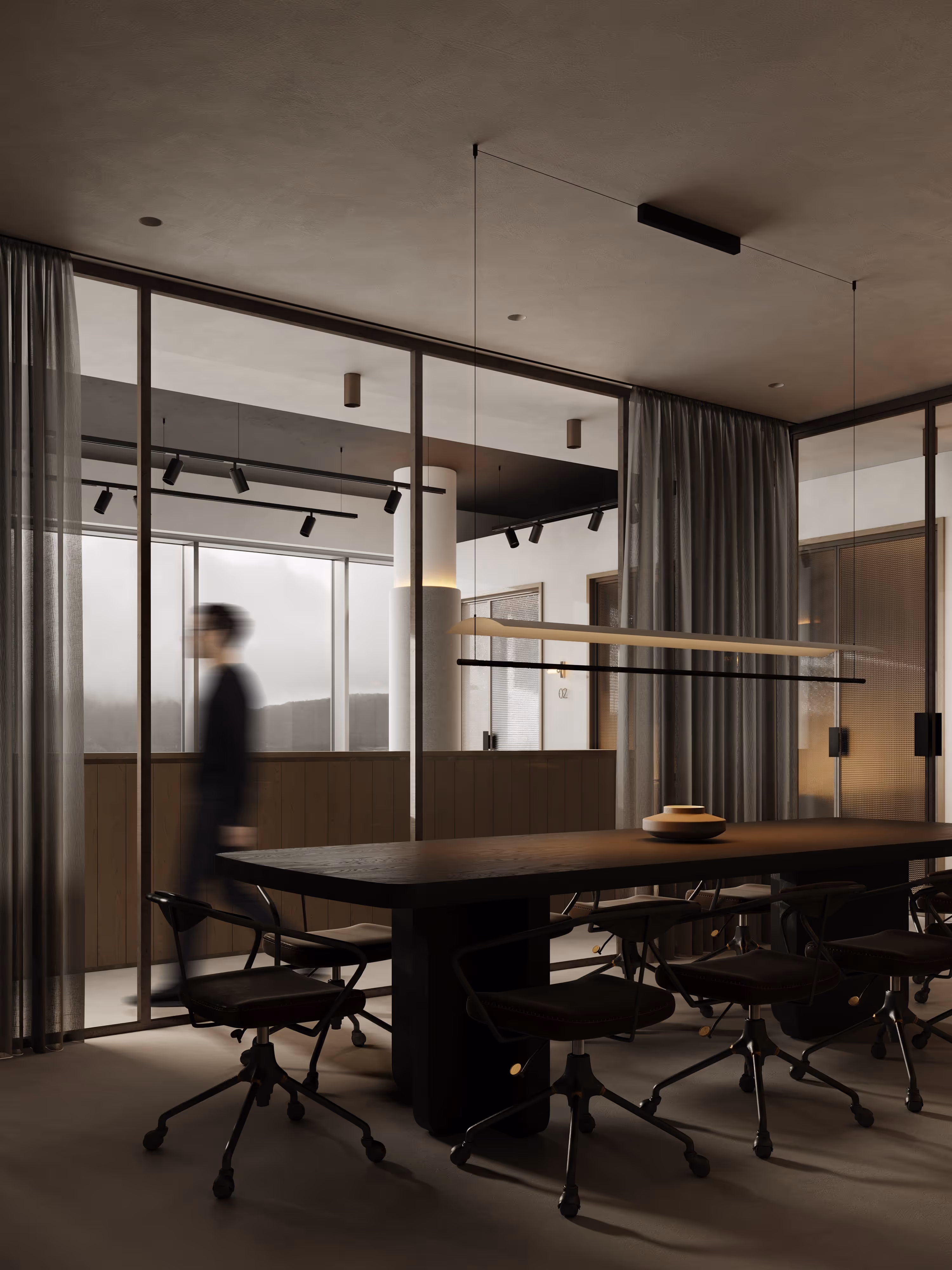 A modern conference room with large glass walls and track lighting. The space is designed to feel open and connected, offering a professional yet creative atmosphere for collaboration.