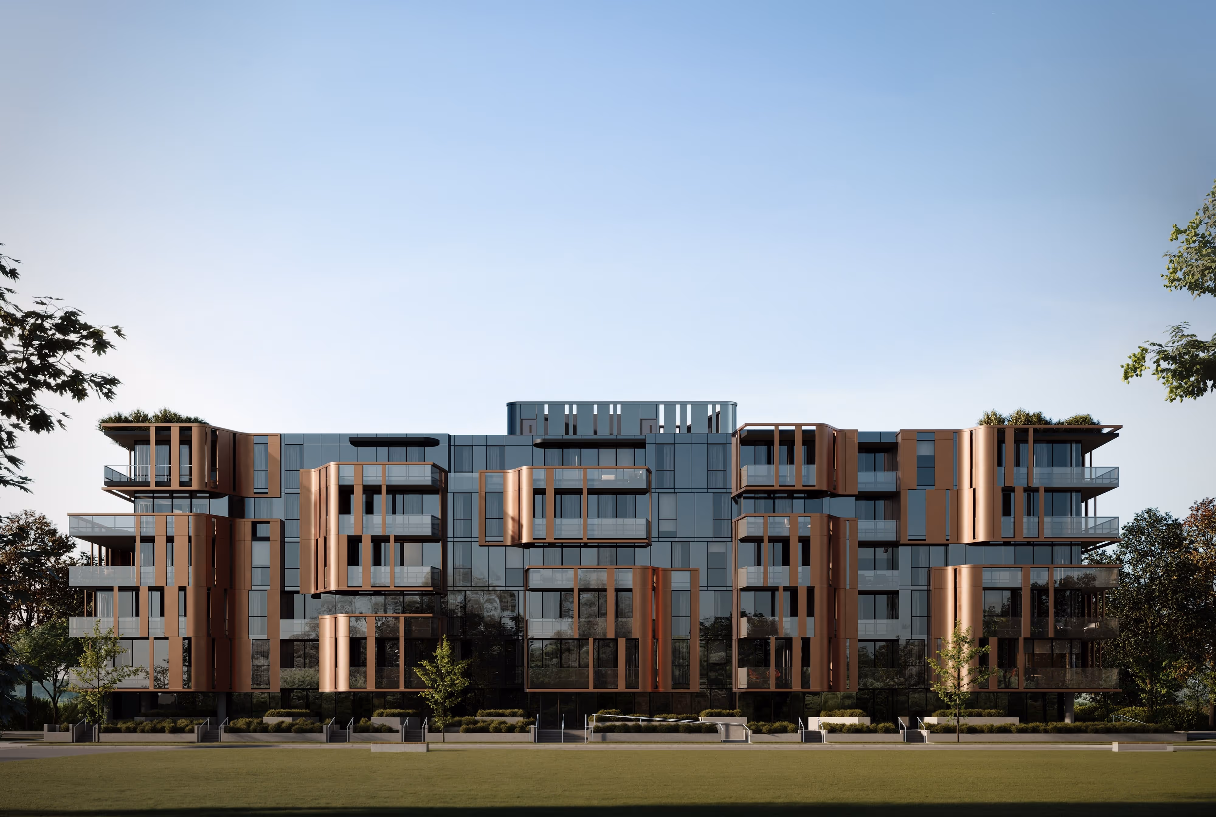 A wide-angle view of a modern residential building with copper-toned metal accents and large glass windows, set against a clear blue sky.