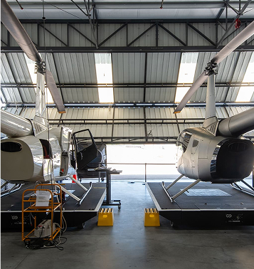 Hangar with two work in progress helicopters on a podium