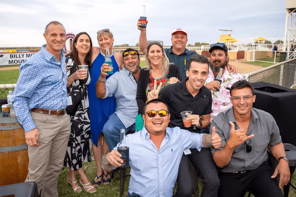 happy, smiling group of people, some with beverages raised