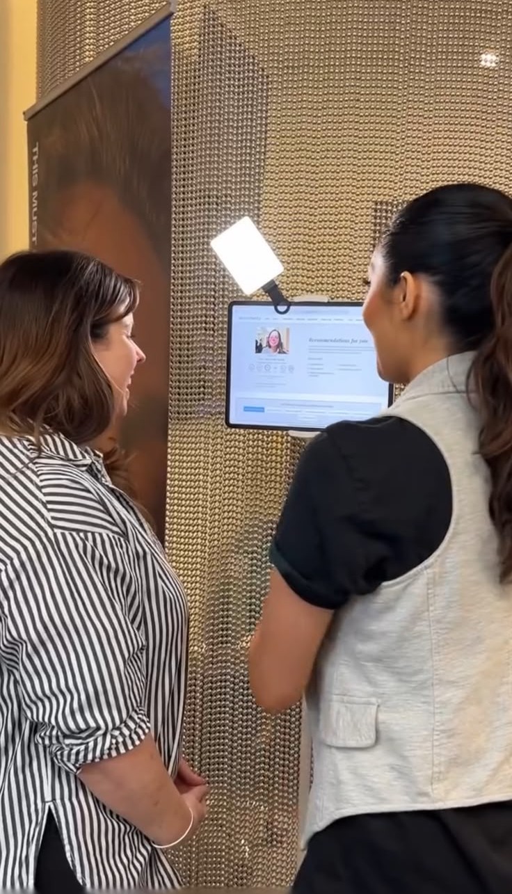 A beauty professional guiding a shopper through a live Tangent consultation at a partner location