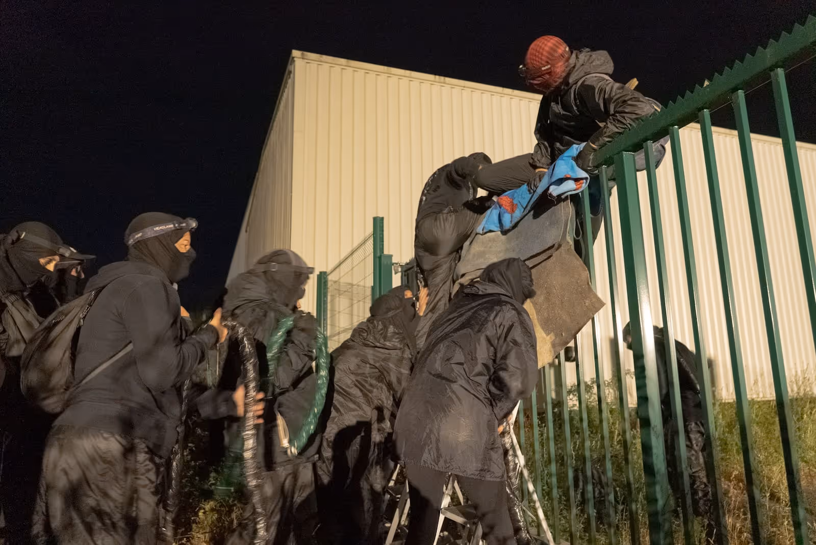 Des militants escaladent la grille de l'abattoir de Boulazac Isle Manoire, en Dordogne, près de Périgueux, ce lundi 7 juillet 2025. (Pedro Brito Da Fonseca)