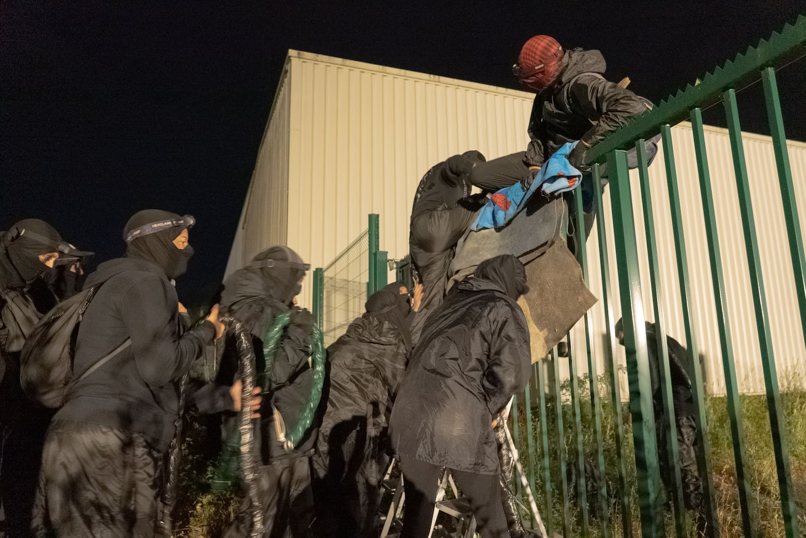 Des militants escaladent la grille de l'abattoir de Boulazac Isle Manoire, en Dordogne, près de Périgueux, ce lundi 7 juillet 2025. (Pedro Brito Da Fonseca)