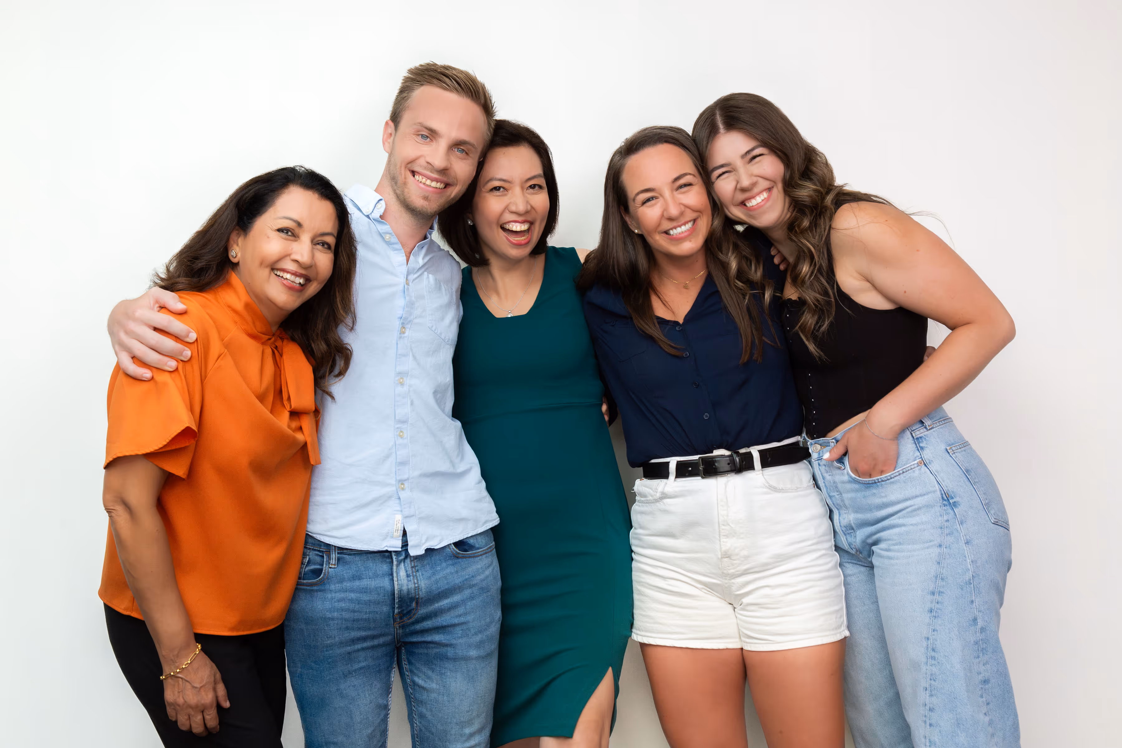 A group of life coaches at different ages standing together and smiling