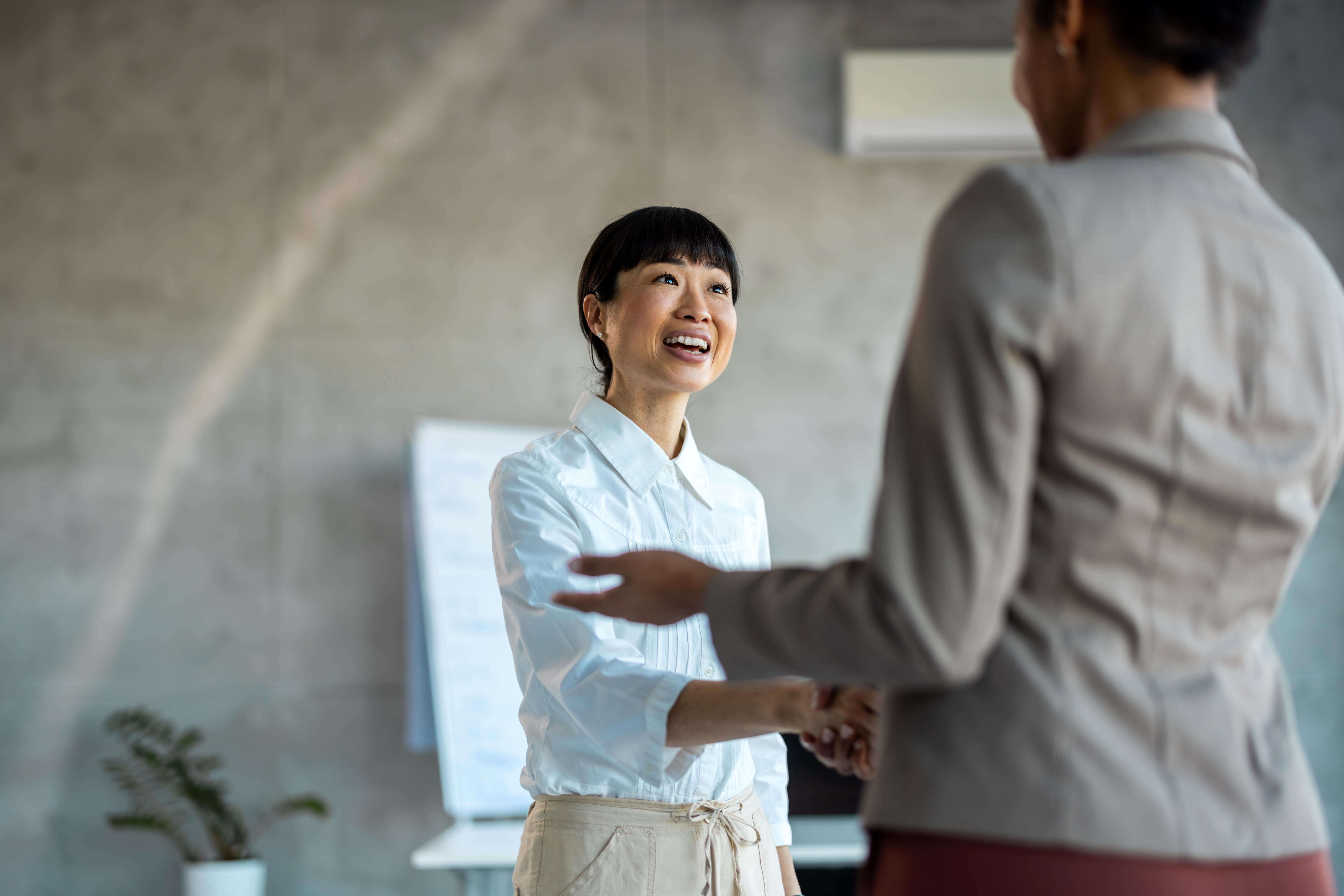 A life coach shaking hands with her client