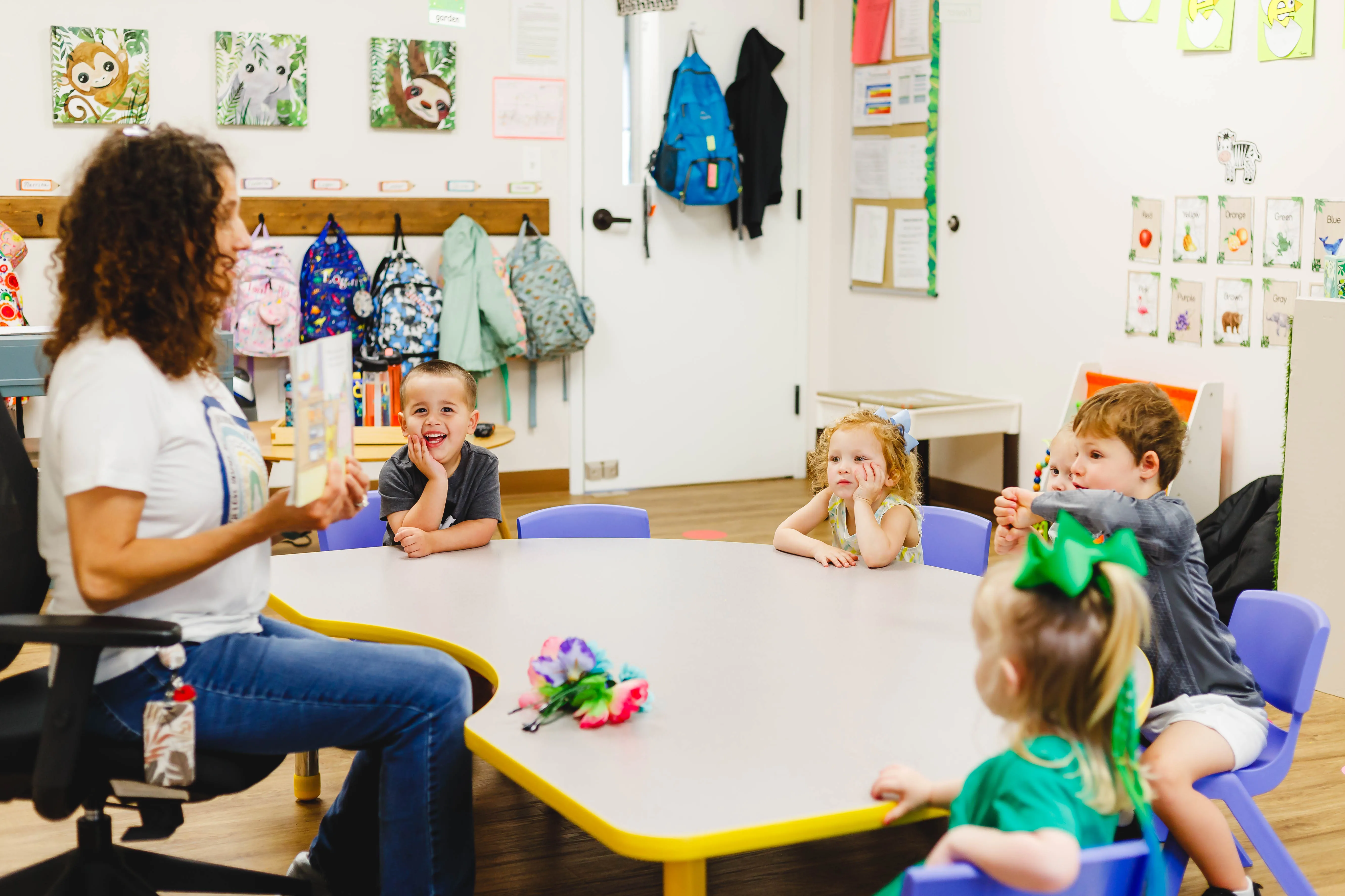 Teacher reading a book to five kids.