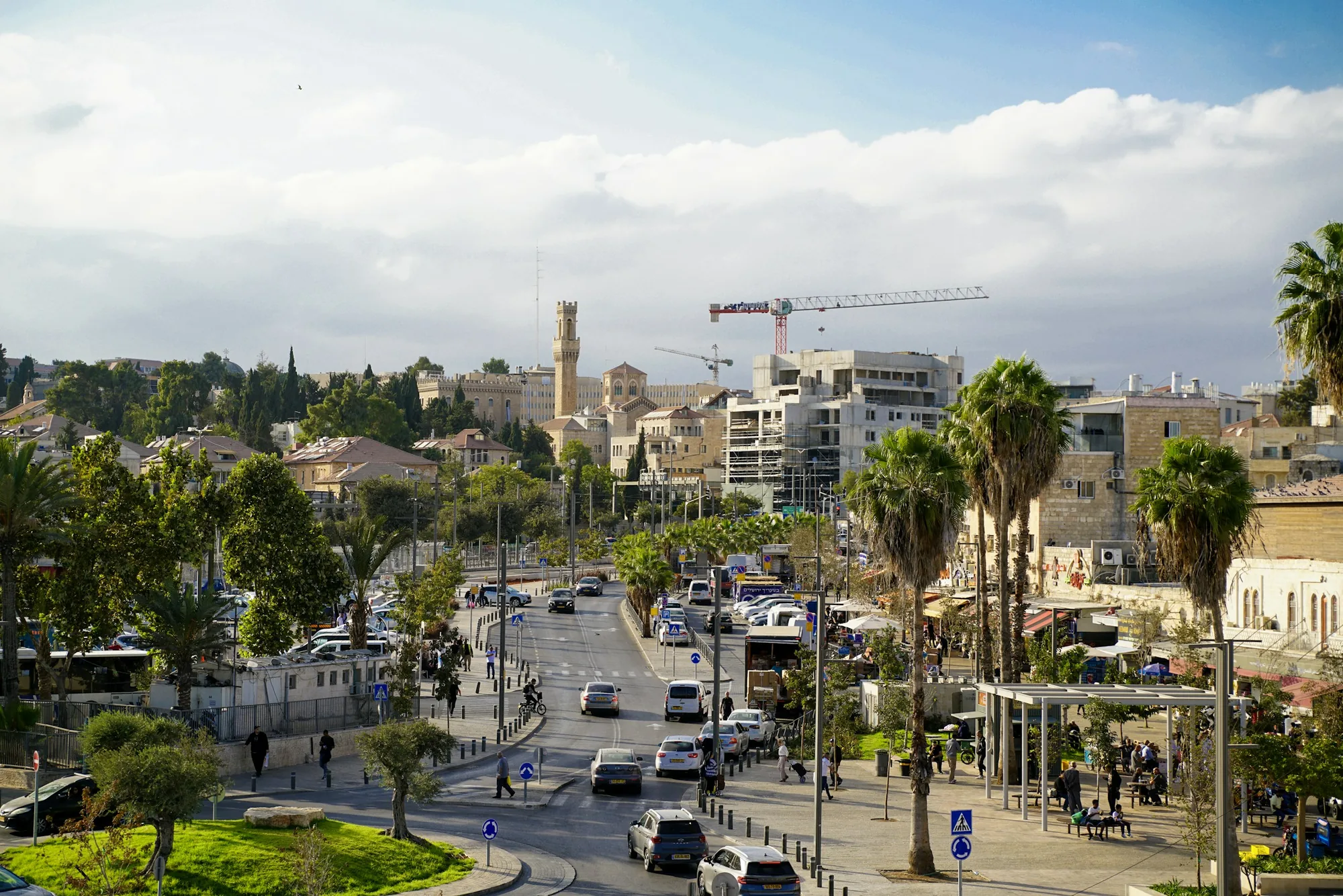 רחוב עירוני עמוס עם דקלים ובנייני מגורים