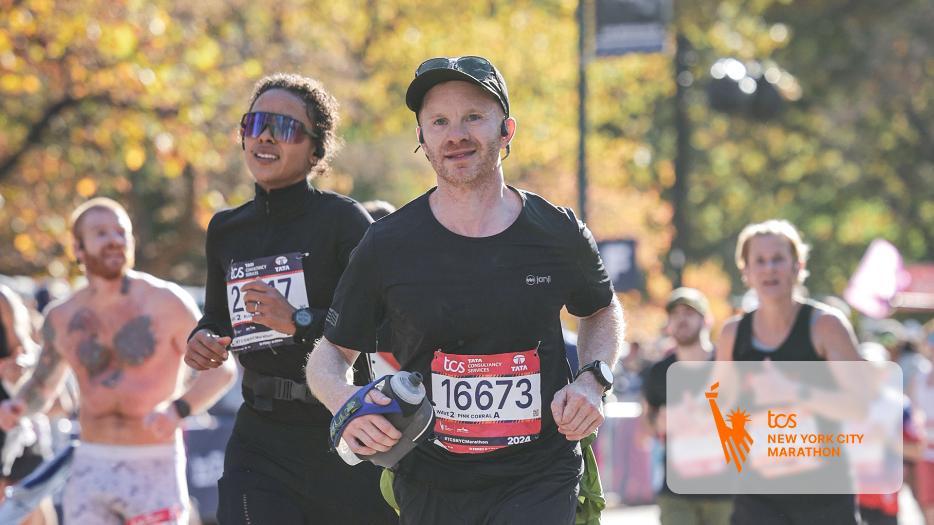 Runners including a man with bib 16673 compete in a sunny New York City Marathon race.