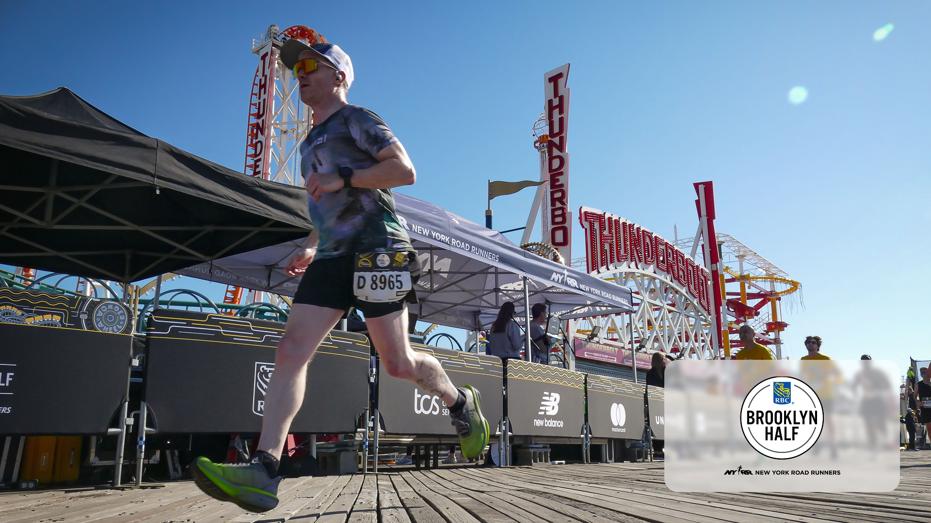 Runner wearing bib 8965 runs past the Thunderbolt roller coaster on a sunny day at Brooklyn Half race.