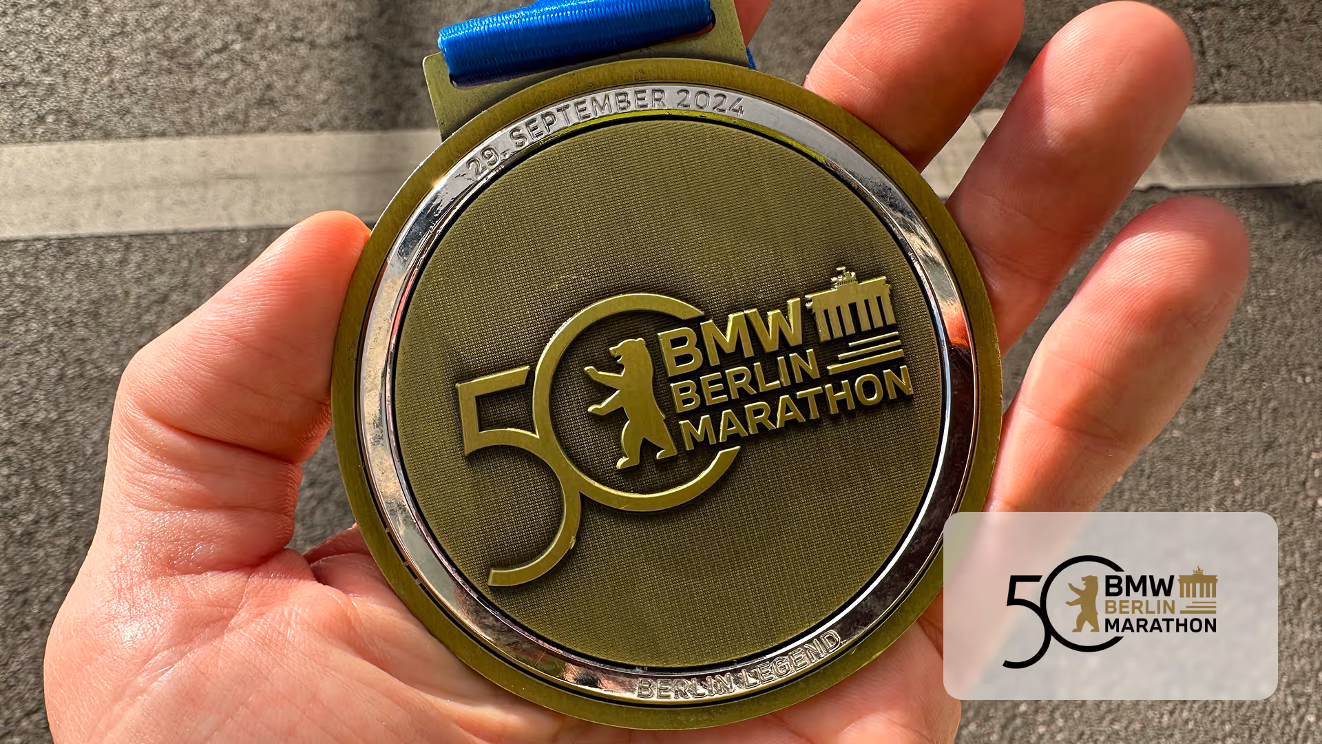 Hand holding a BMW Berlin Marathon 50th anniversary medal dated 29 September 2024.