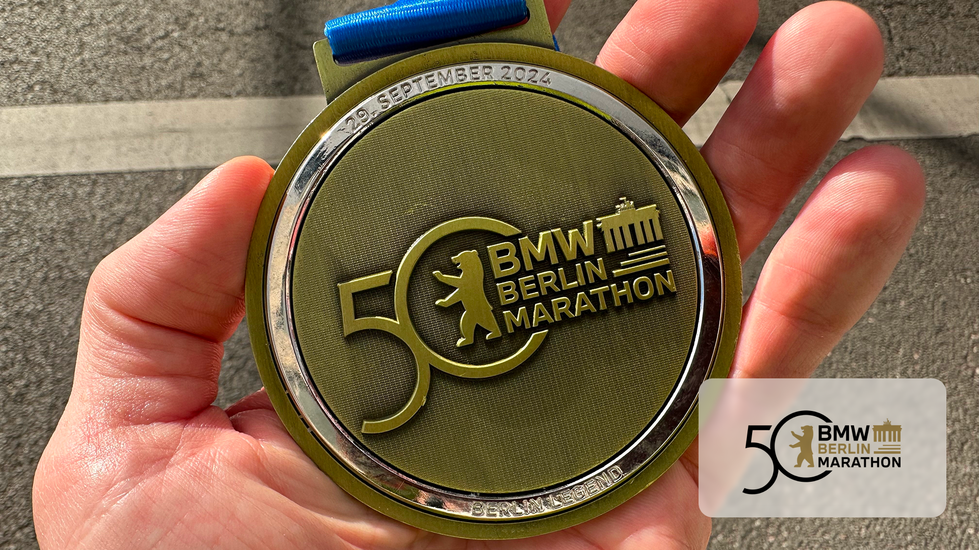 Hand holding a BMW Berlin Marathon 50th anniversary medal dated 29 September 2024.