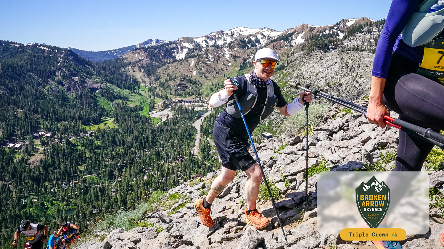 Runners hiking Rocky mountain trail with trekking poles during Broken Arrow Sky Race in Squaw Valley.
