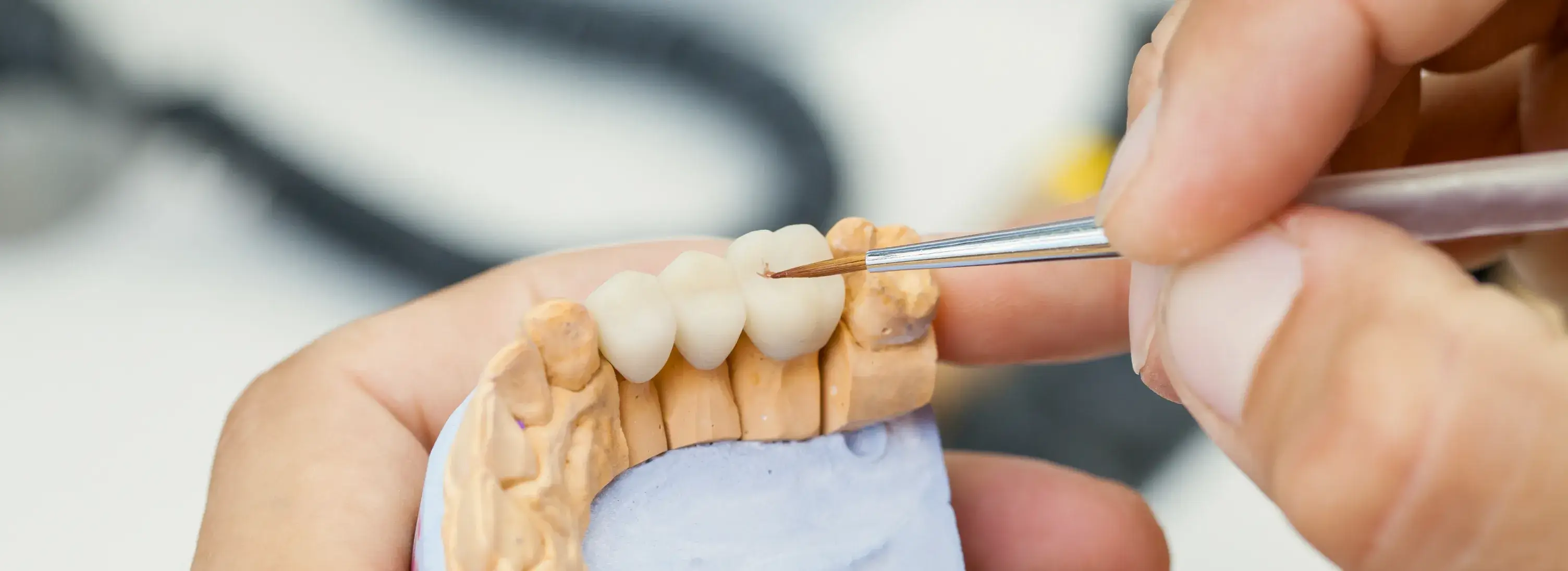 A close up of a person cutting a tooth.