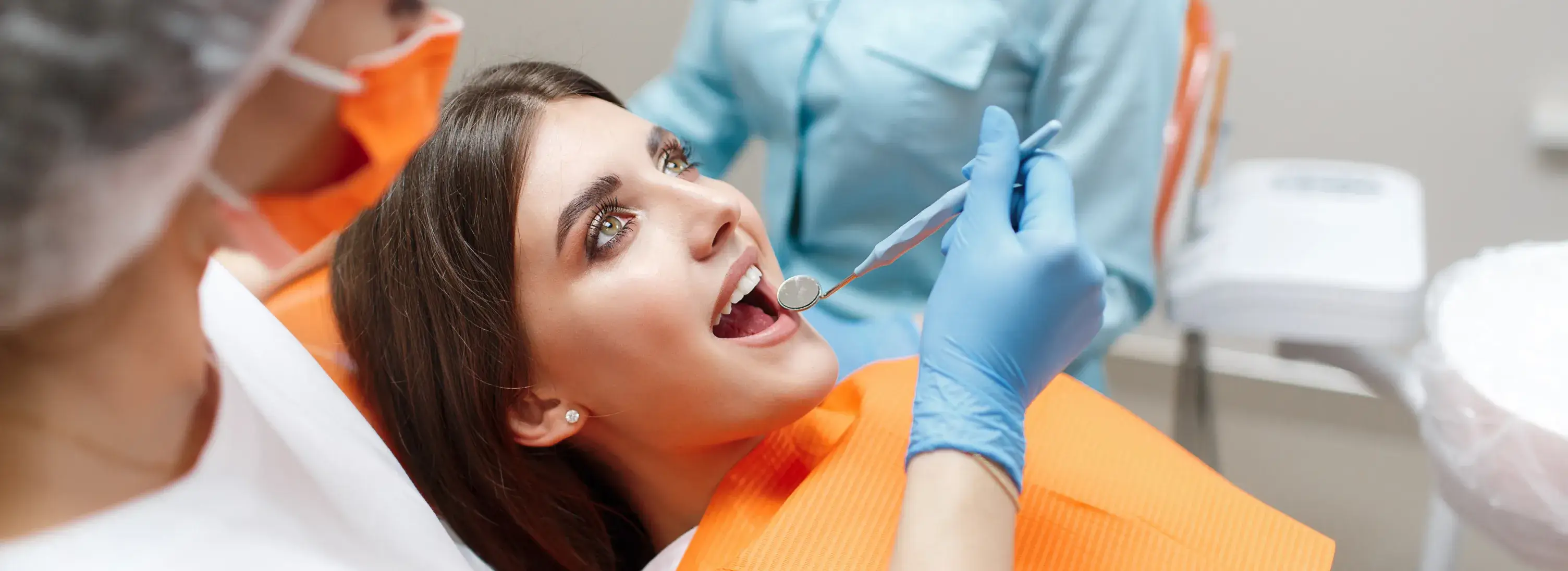 A woman getting her teeth checked by a dentist.