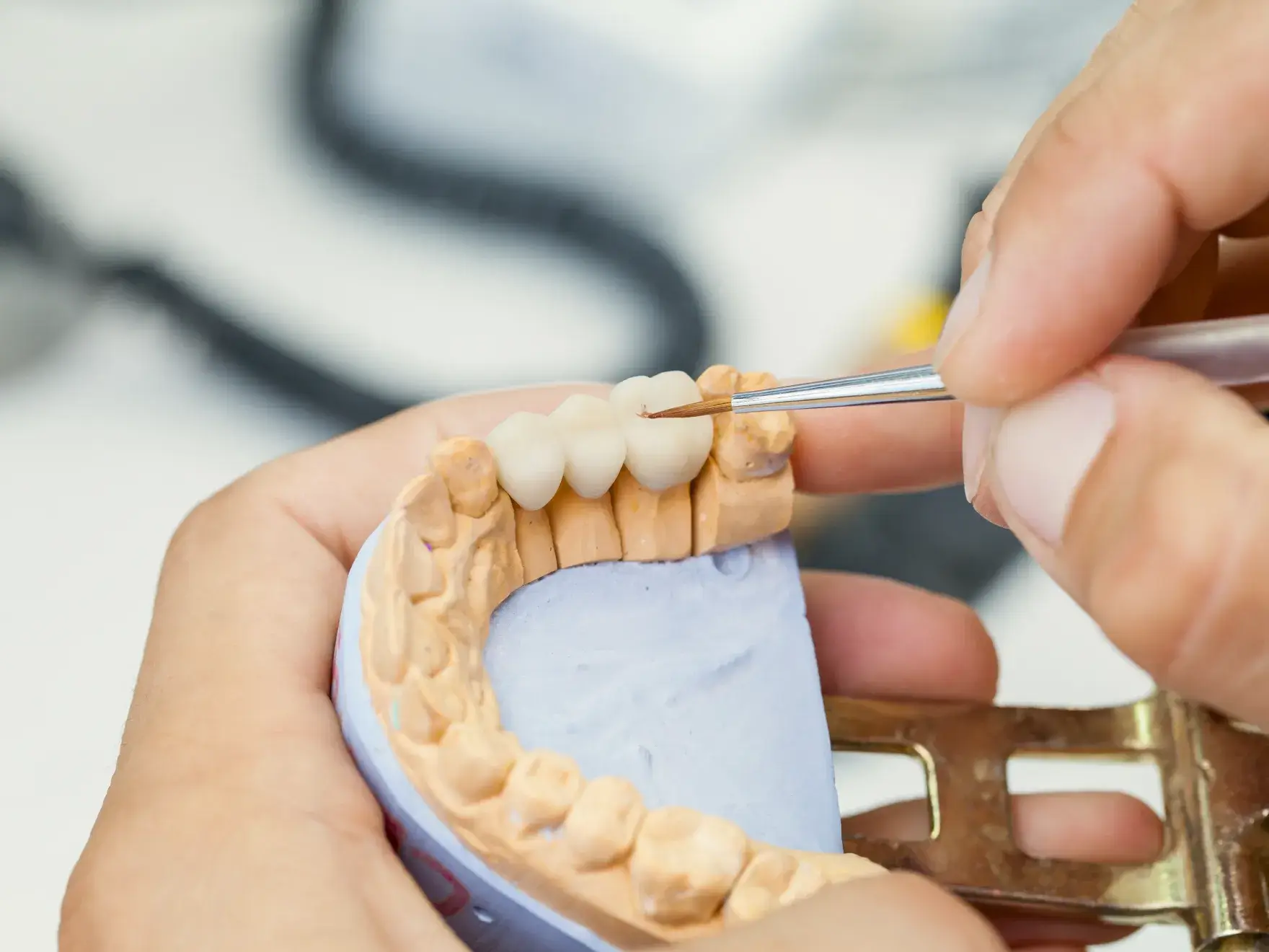 A person cutting a tooth with a pair of scissors.