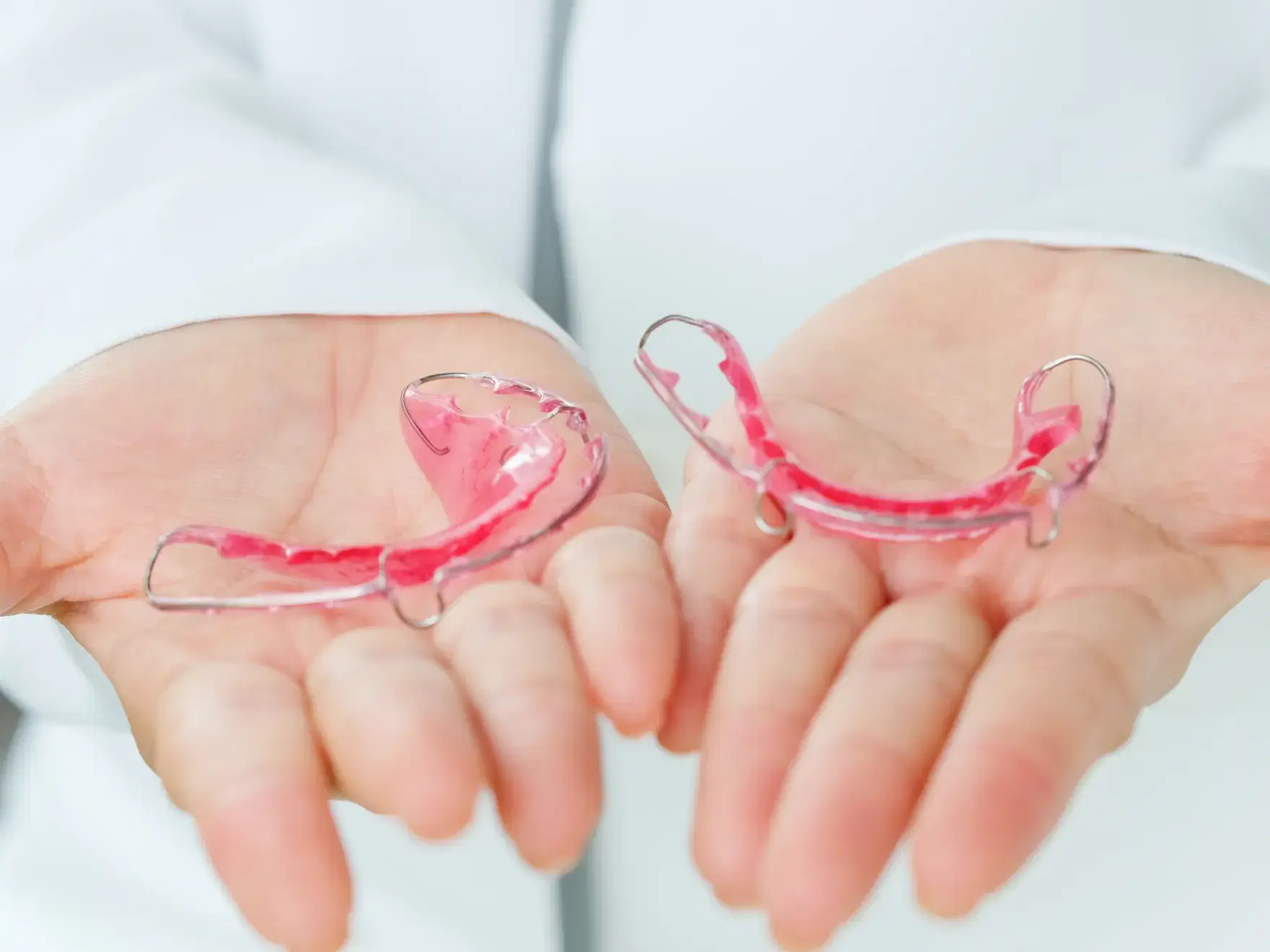 A person holding two pieces of glass in their hands.