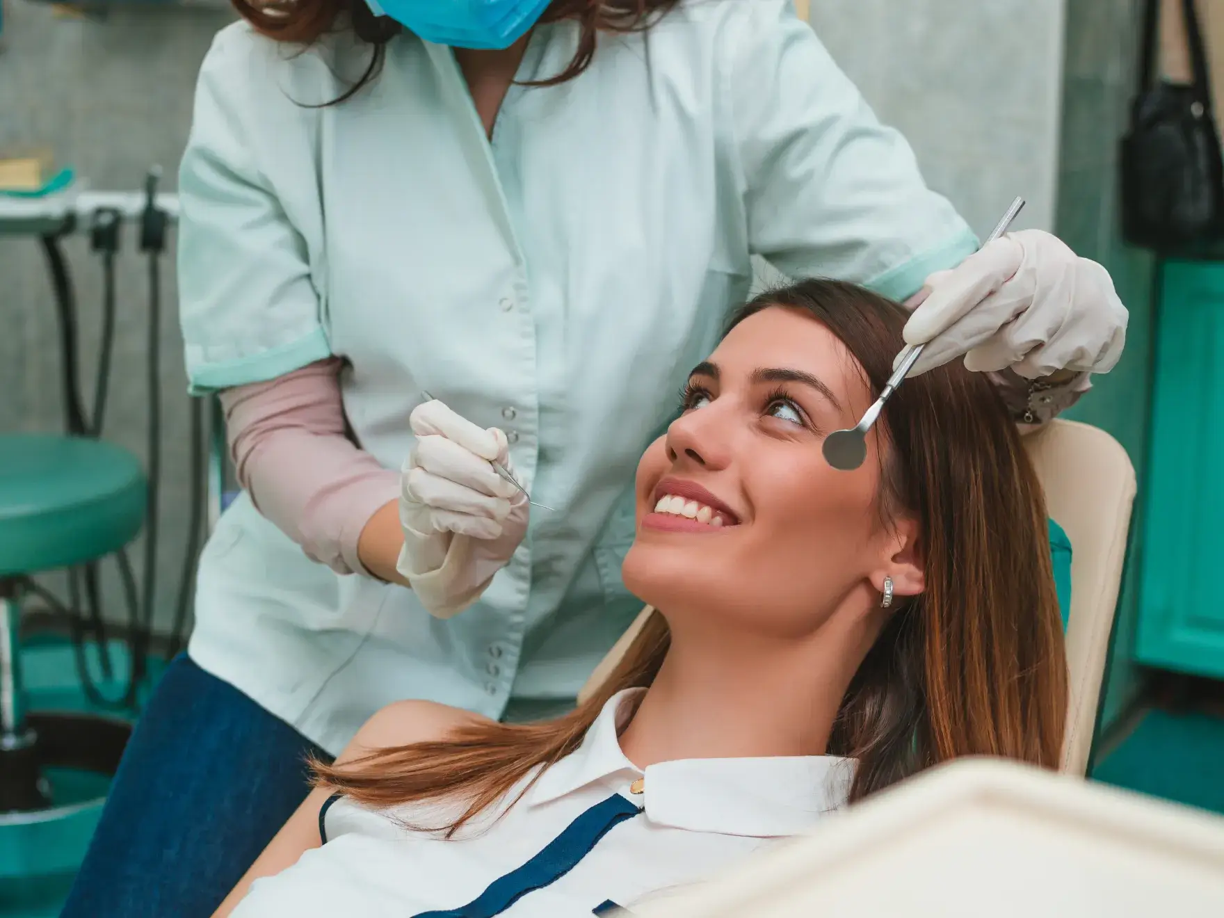 A woman getting her teeth brushed by a dentist.
