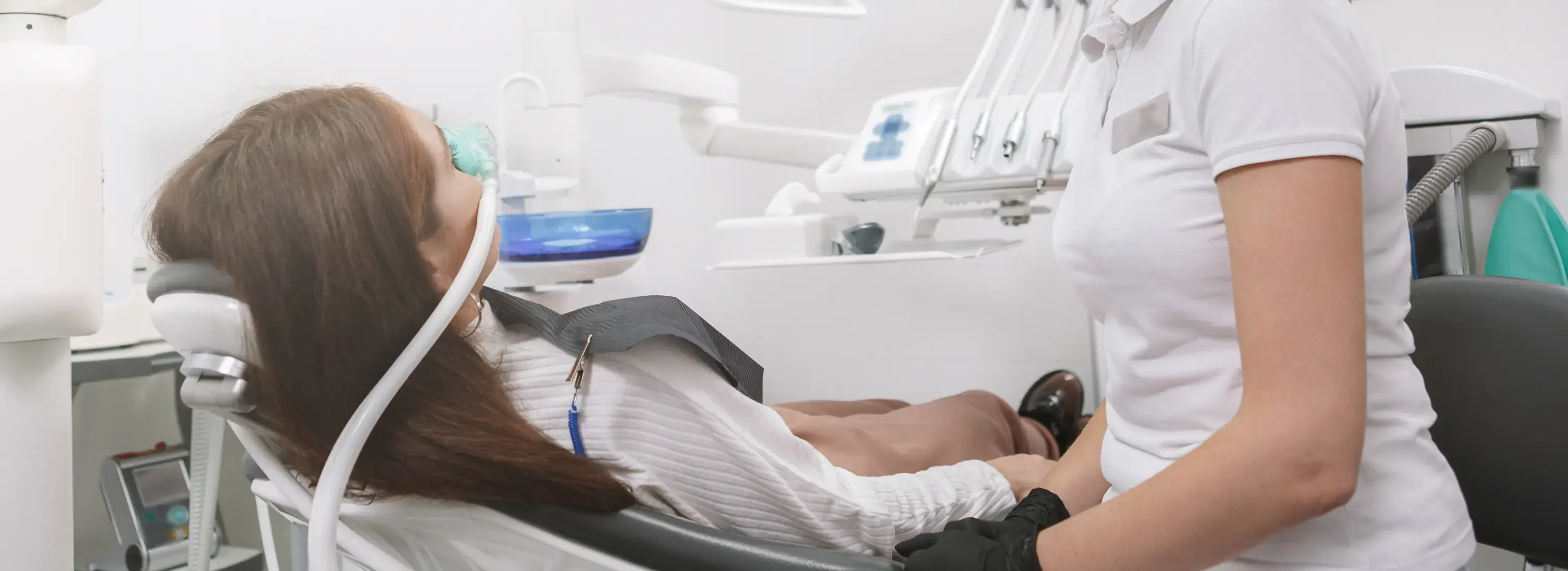 A woman sitting in a chair in a dentist's office.
