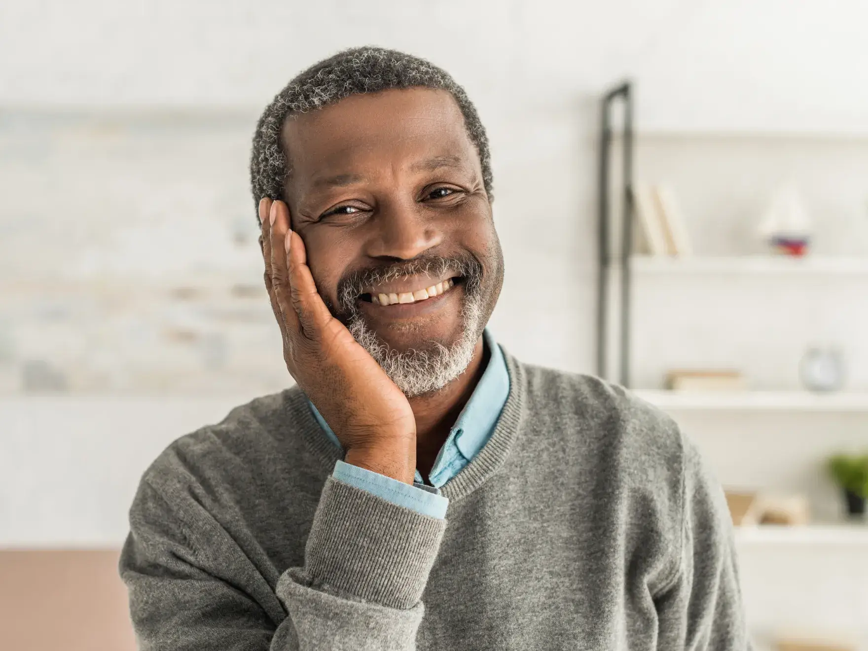 A man with a gray beard and a blue shirt.