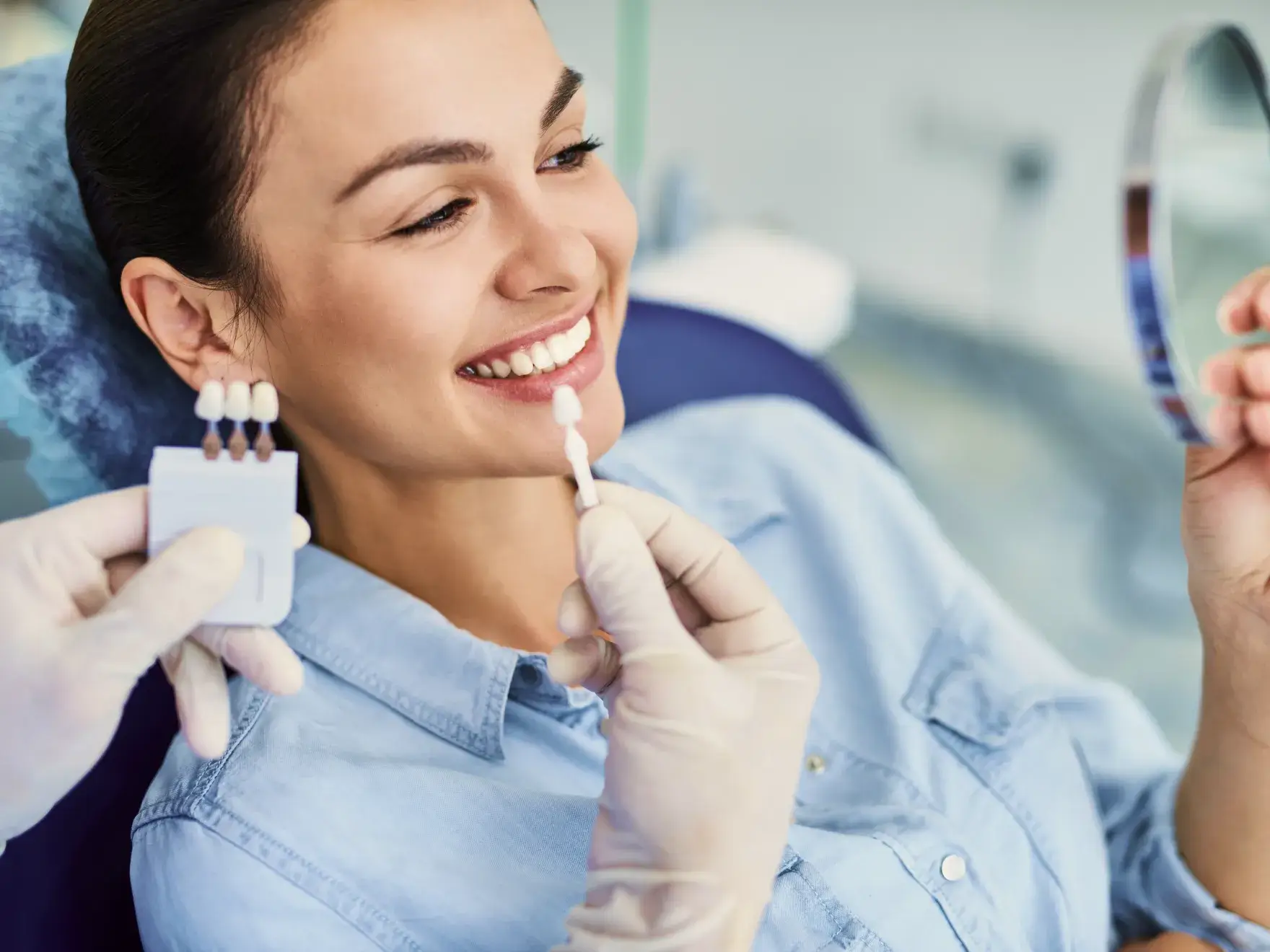 A woman is smiling while holding a toothbrush.