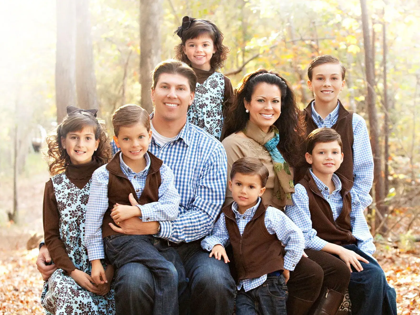 A family poses for a picture in the woods.