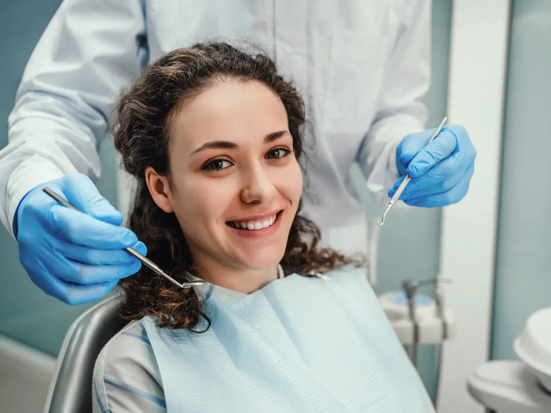 A woman sitting in a chair with a toothbrush in her mouth.