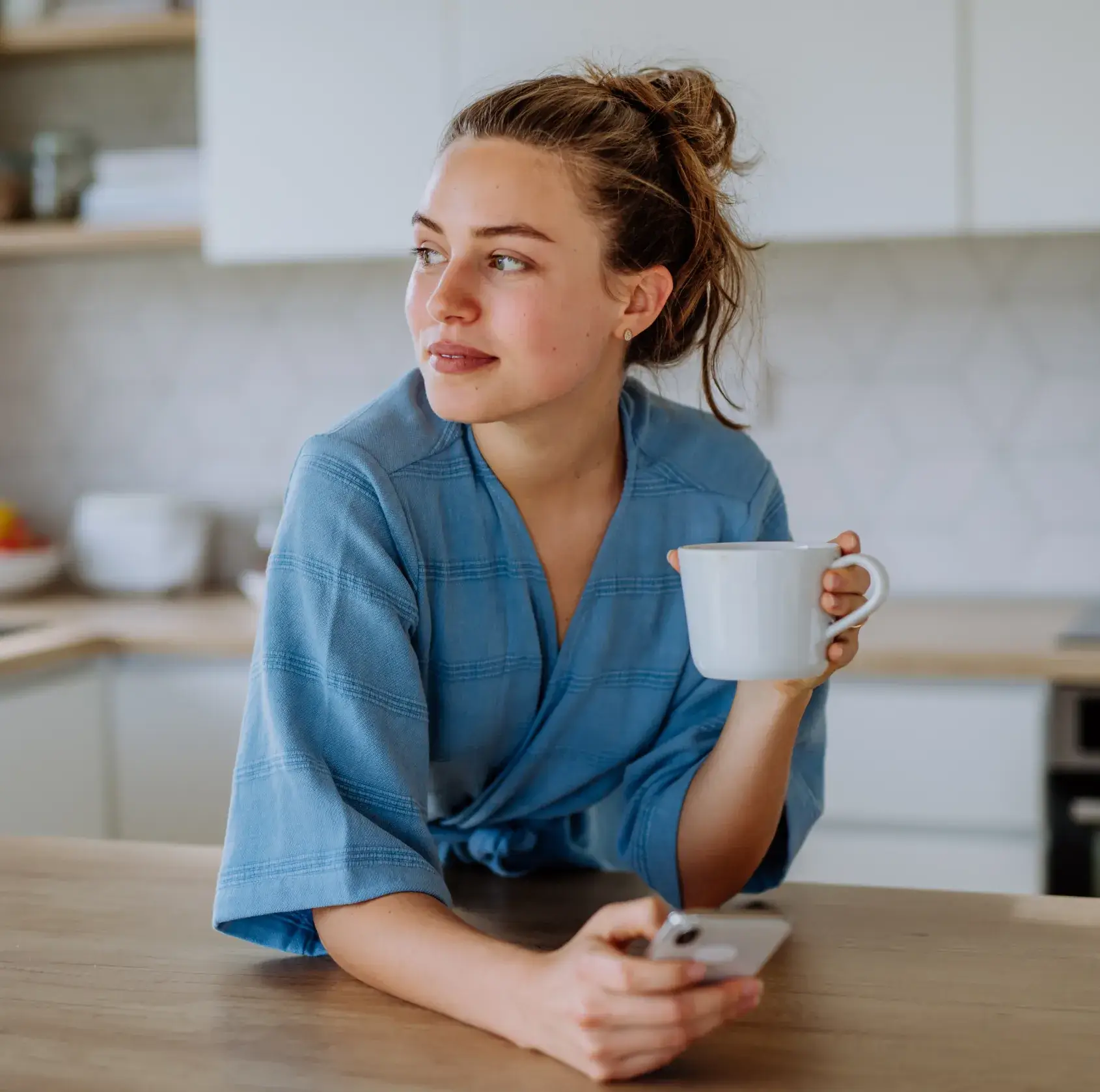 A woman sitting at a table with a cup of coffee.