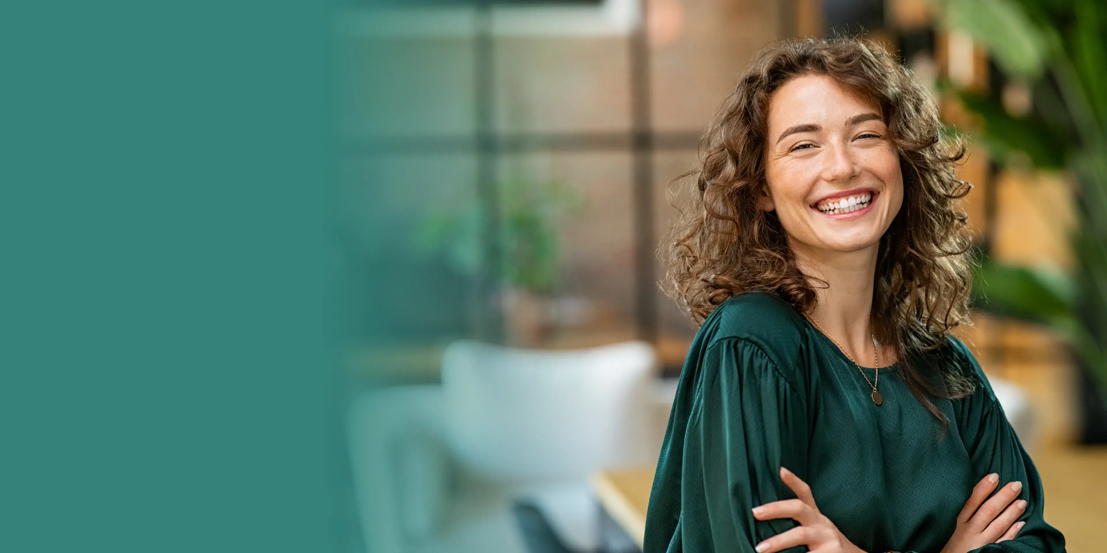 A woman in a green shirt is smiling.