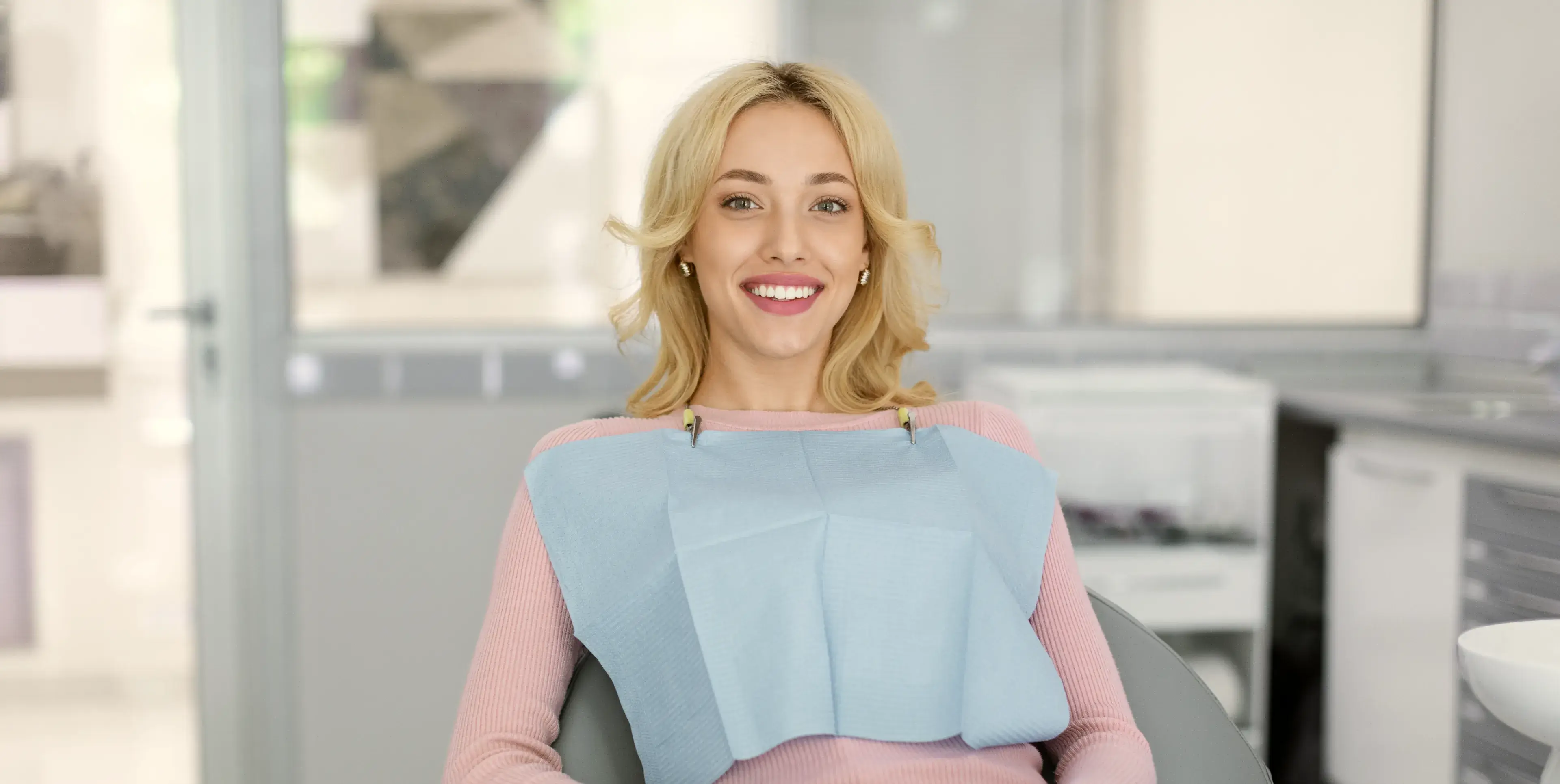 A woman sitting in a chair smiling at the camera.