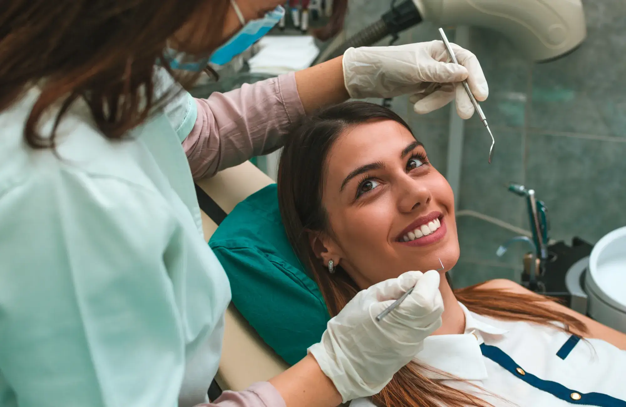 A woman getting her teeth checked by a dentist.