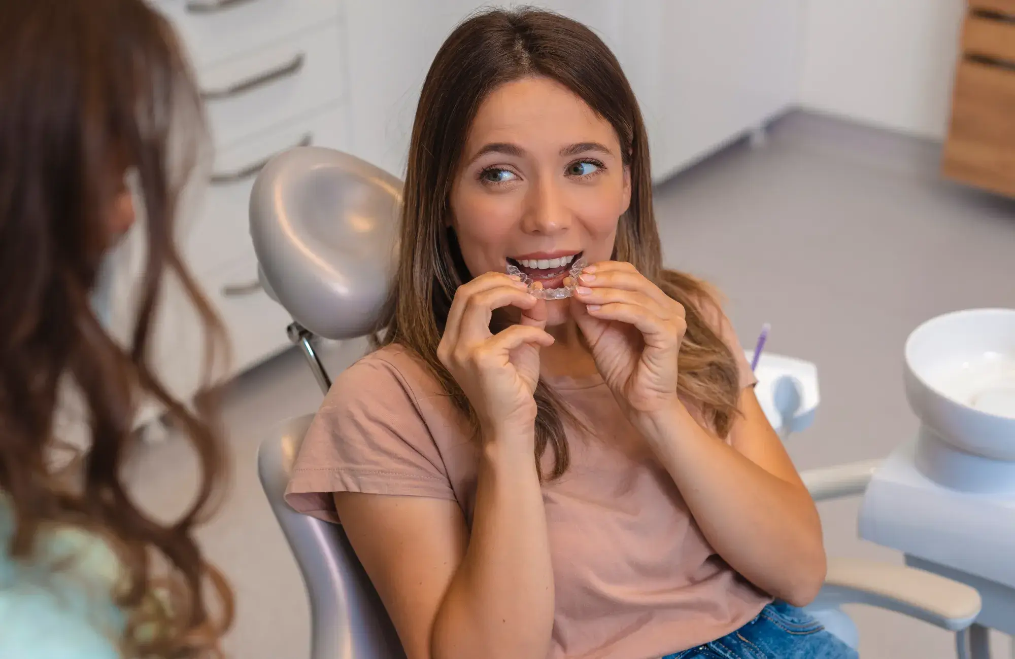 A woman sitting in a chair while brushing her teeth.